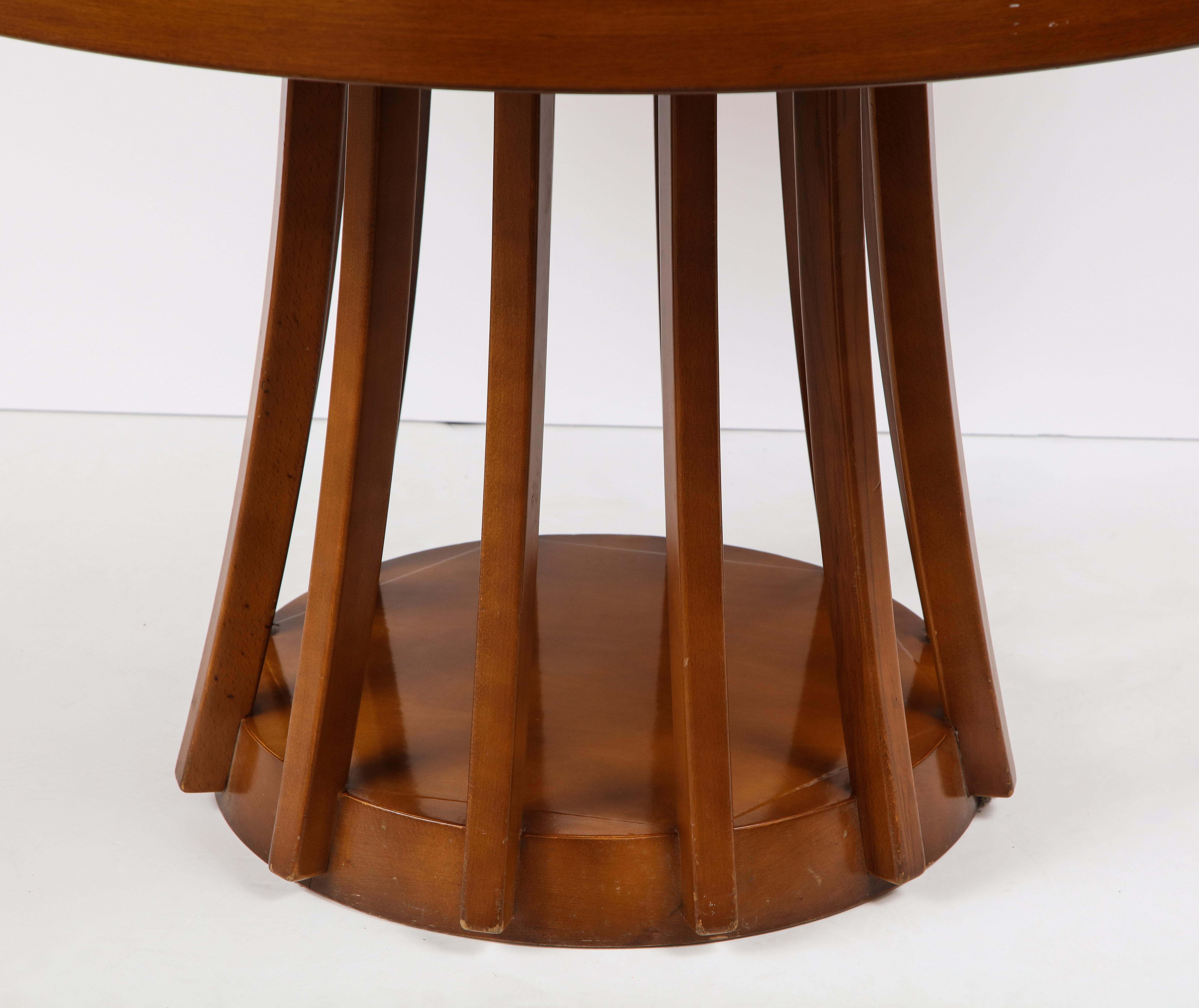 An extendable mahogany center or dining table by Angelo Mangiarotti, manufactured by La Sorgente Dei Mobili, 1972. 
The twelve legs connected by a circular base support the top. 
Size: 27 3/4