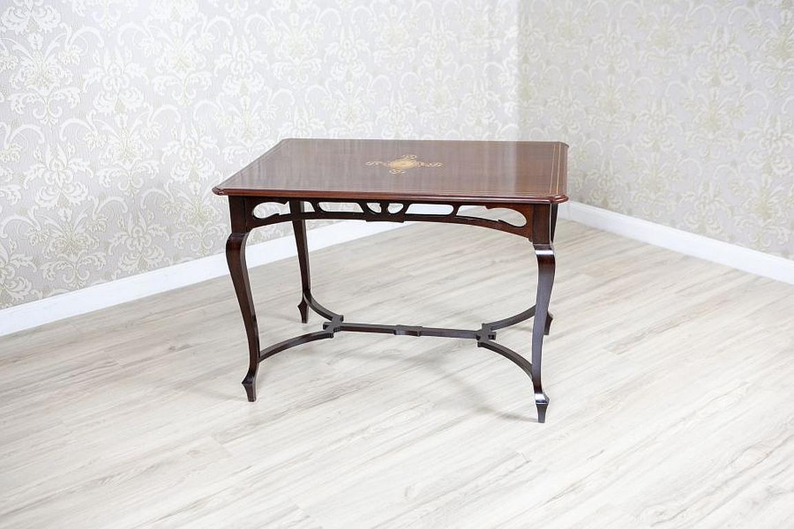 Art Nouveau Mahogany Center Table From the Early 20th Century with Floral Inlays

We present you this center mahogany table in the Art Nouveau style, made in Western Europe.
The rectangular top with a chamfered trim is placed on lean, bent legs,