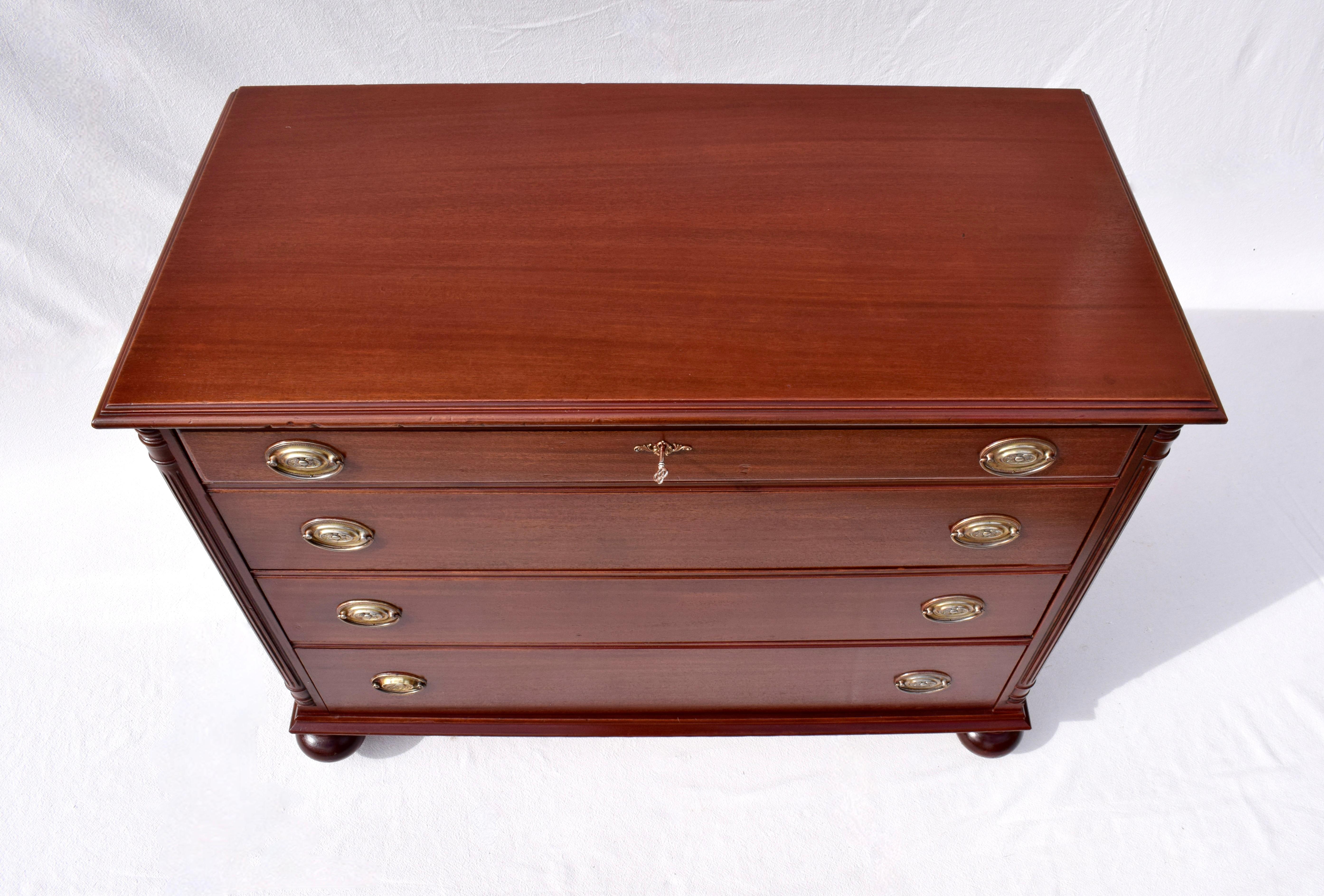 An impressive Mahogany chest of four drawers with working lock & key and marvelous cannonball feet on casters. Newly refinished; generous storage, ready for use.
