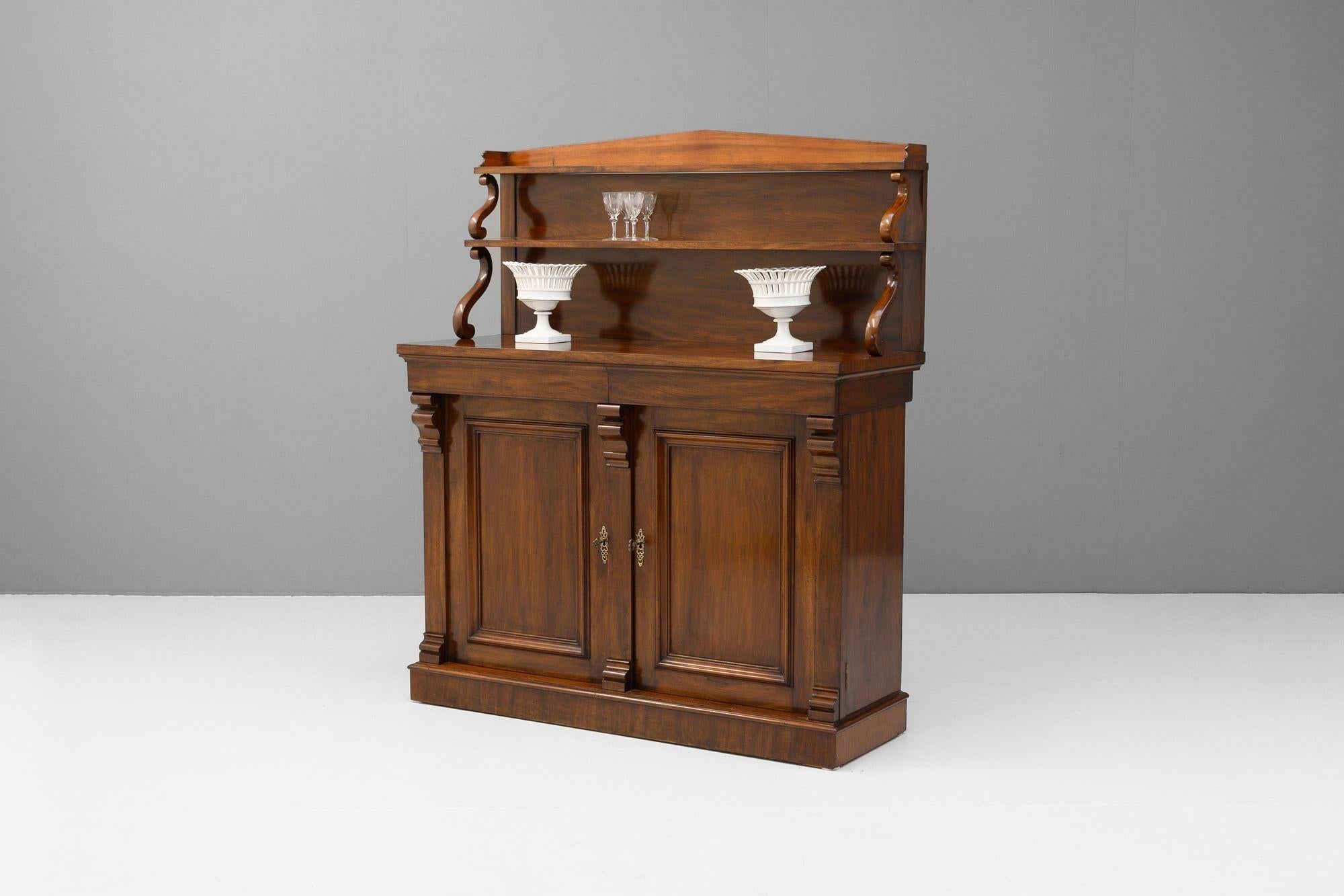 Chifonnier a due ante in mogano con schienale a due livelli. Circa 1860.
H. 154 cm x L. 131 cm x P. 49 cm