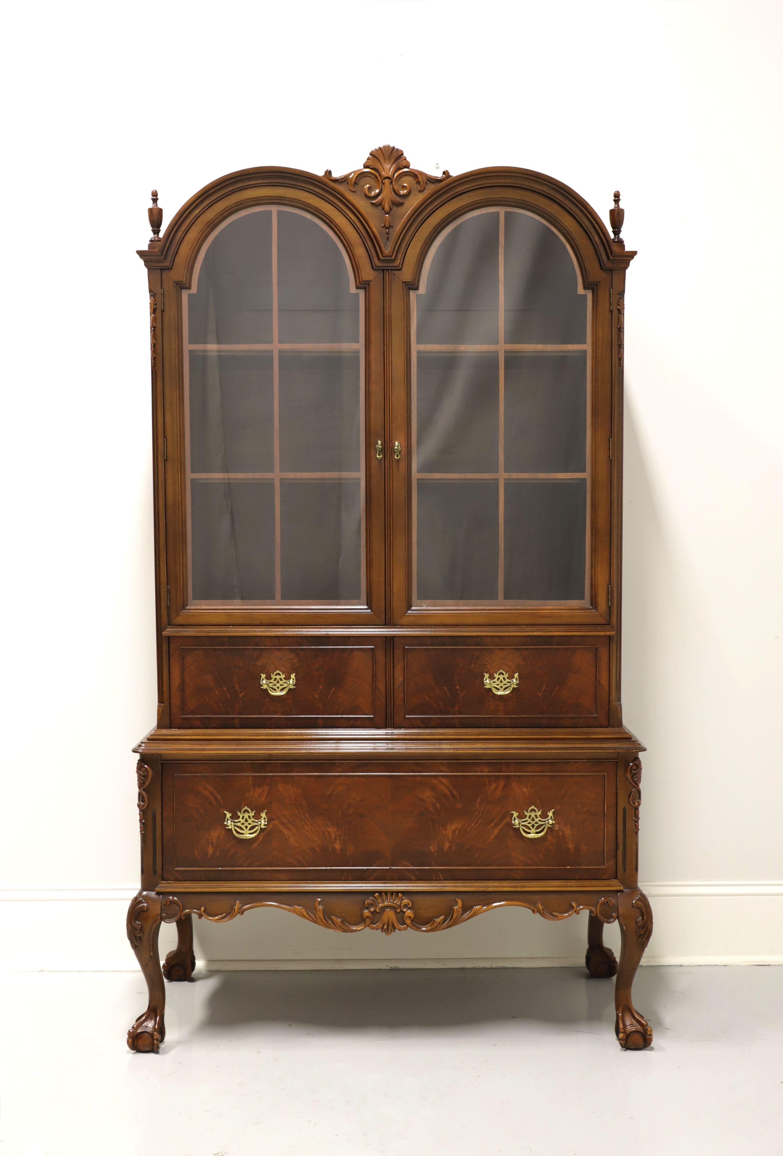 A Chippendale style display cabinet by Lammert's Furniture, of Saint Louis, Missouri, USA. Mahogany with brass hardware, double bonnet top with decorative center carving & finials, raised drawer fronts, carved knees and ball in claw feet. Upper