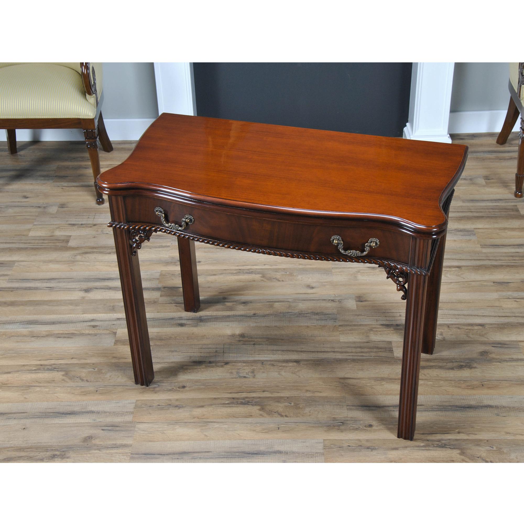 This large straight leg Mahogany Chippendale Game Table has a serpentine top with figural mahogany grain and a crisply moulded edge. The flamed veneered frieze with high quality rococo style hardware and fine gadroon carving sits above pierced and