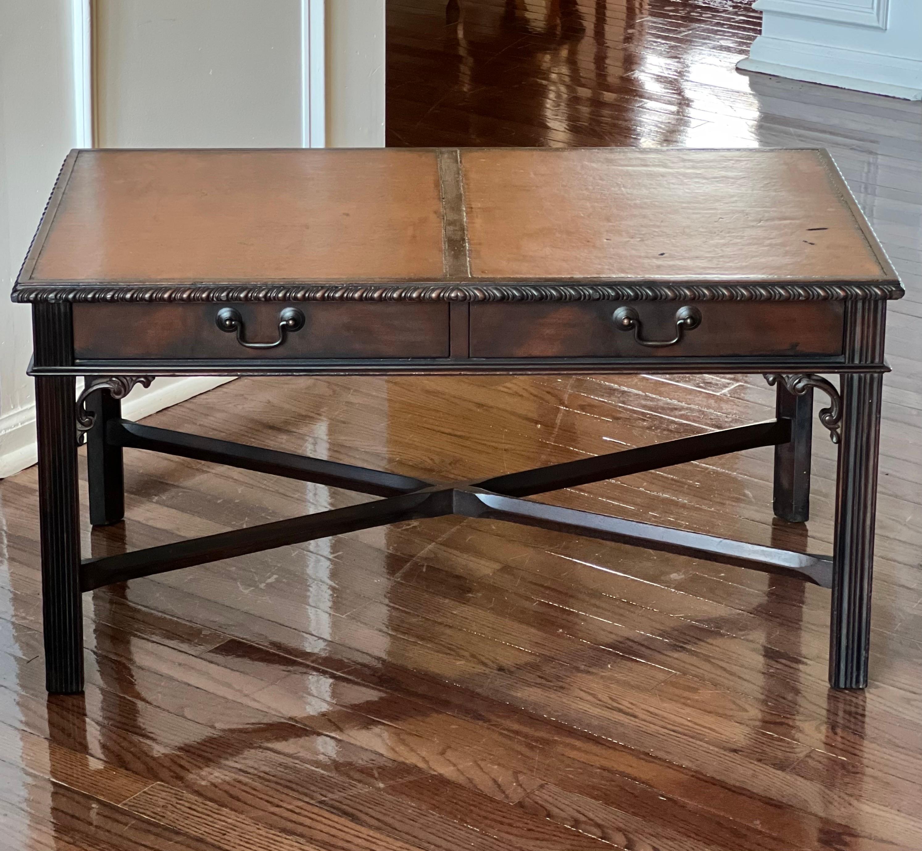Stately mahogany Chippendale style coffee table by Imperial of Grand Rapids, c. 1940's.

A great table featuring a dual panel leather top and two dovetailed drawers with bronze finish hardware. Finely detailed with carved scroll work, square fluted