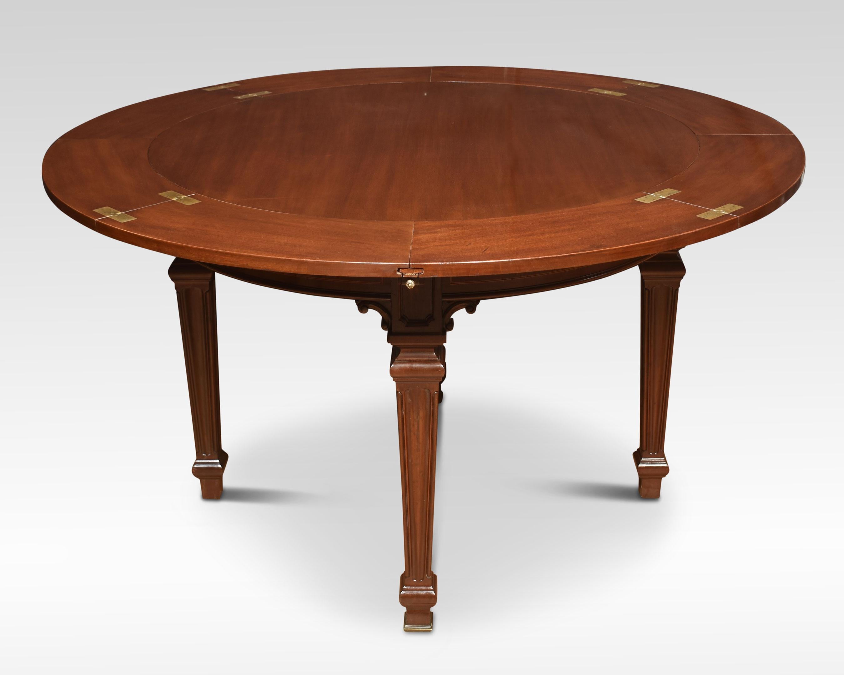 Mahogany inlaid ships dining table, the unusual circular top having four convexed drawers which open to reveal four original mahogany hinged leaves which can be incorporated into the pull-out arms to create a large circular dining surface. Raised up