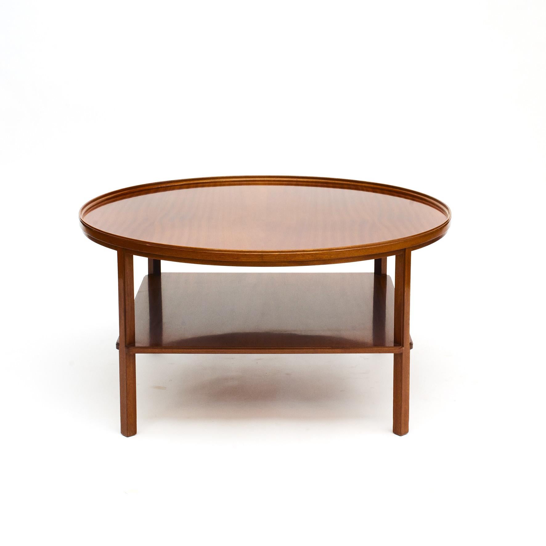 Round mahogany coffee table by Kaare Klint, model 6687.
Cuban mahogany, with lower shelf and a raised rim around the table top.
Designed in 1929 by Kaare Klint, (1888-1954). Produced by Rud. Rasmussen 1929-1950.
Underside with manufacturer's
