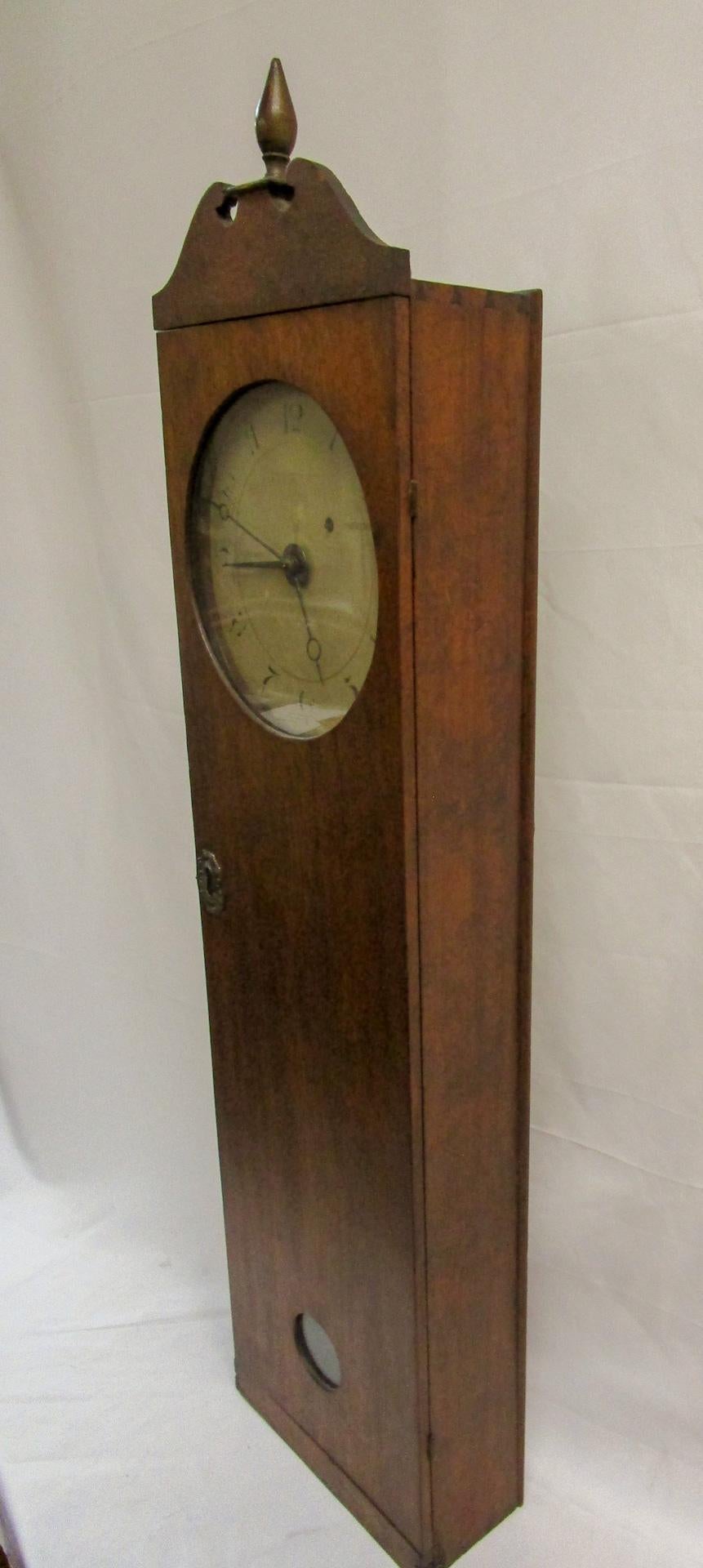 This rare mahogany Coffin Clock was made by Elnathan Taber of Roxbury, Massachusetts, c. 1810. Features include-
Case: arched swan neck pediment with turned wooden
finial over full-length hinged door with glazed dial and
pendulum aperture, and