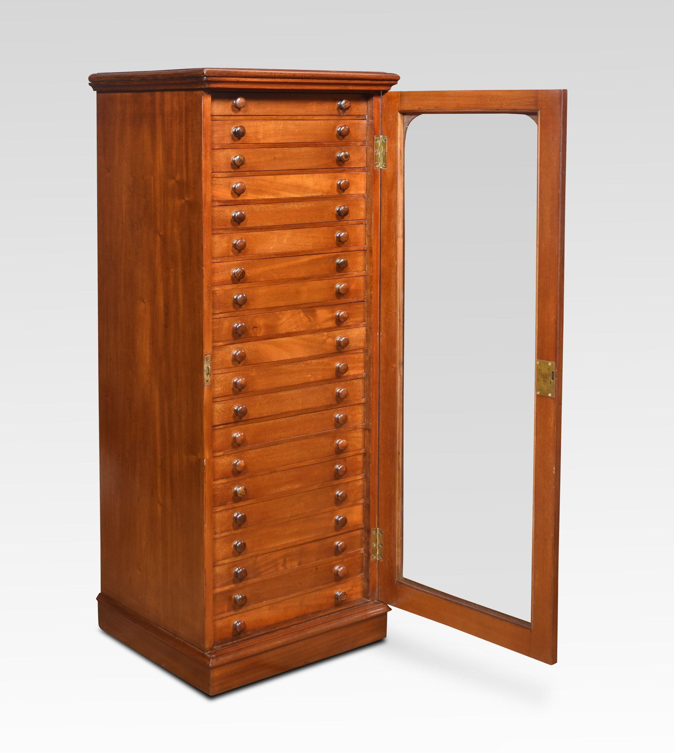 Mahogany collectors cabinet, the square top with moulded edge above large glazed door enclosing twenty drawers with glazed covers and mahogany knobs the internal height of the drawers is one inch. All raised up on a plinth base.
Dimensions
Height 53