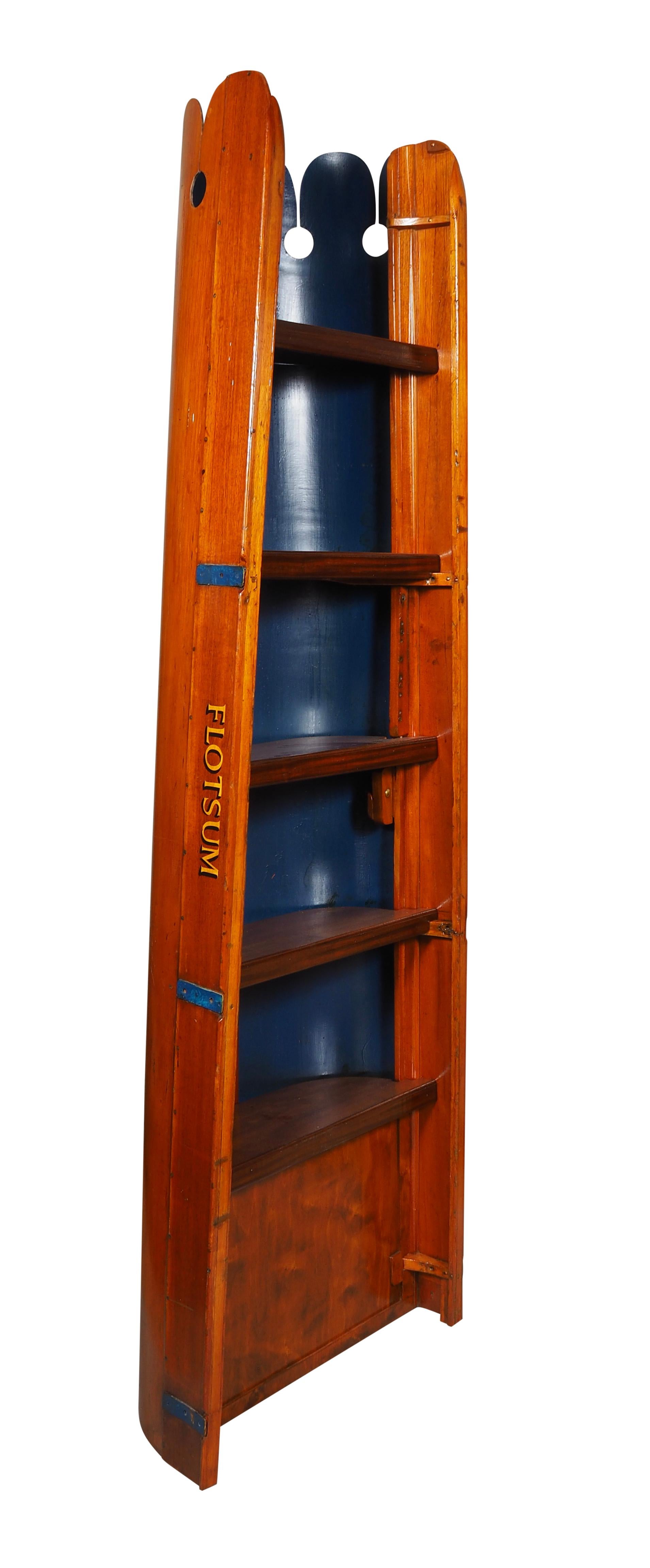 Made from an old crew shell with the letters FLOTSAM on sides with shelves and dark blue background.