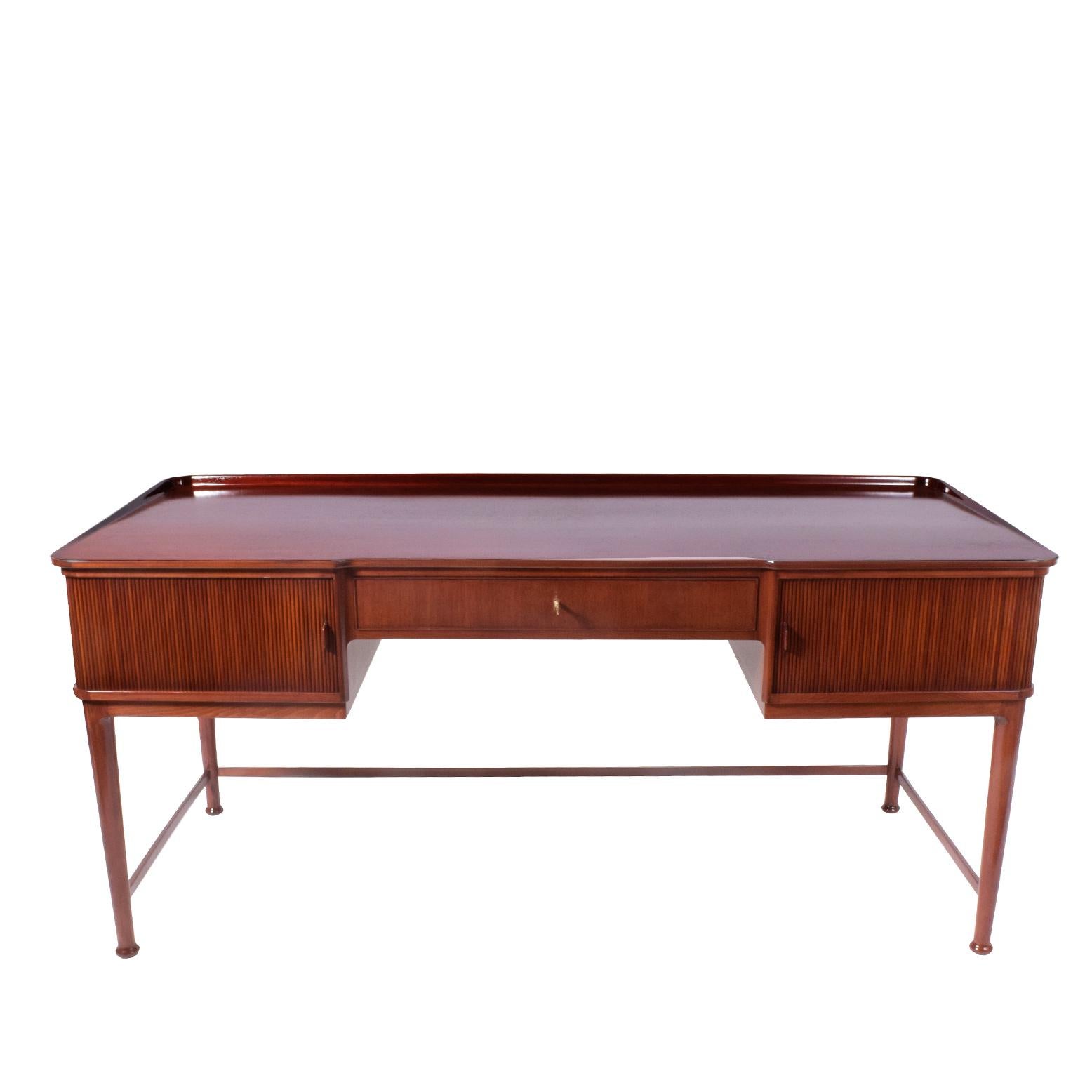 Beautiful mahogany desk with birch interior and tambour doors on each side revealing two drawers each. Top with lip; back of desk also has tambour doors revealing shelves. Made for Svenskt Tenn.