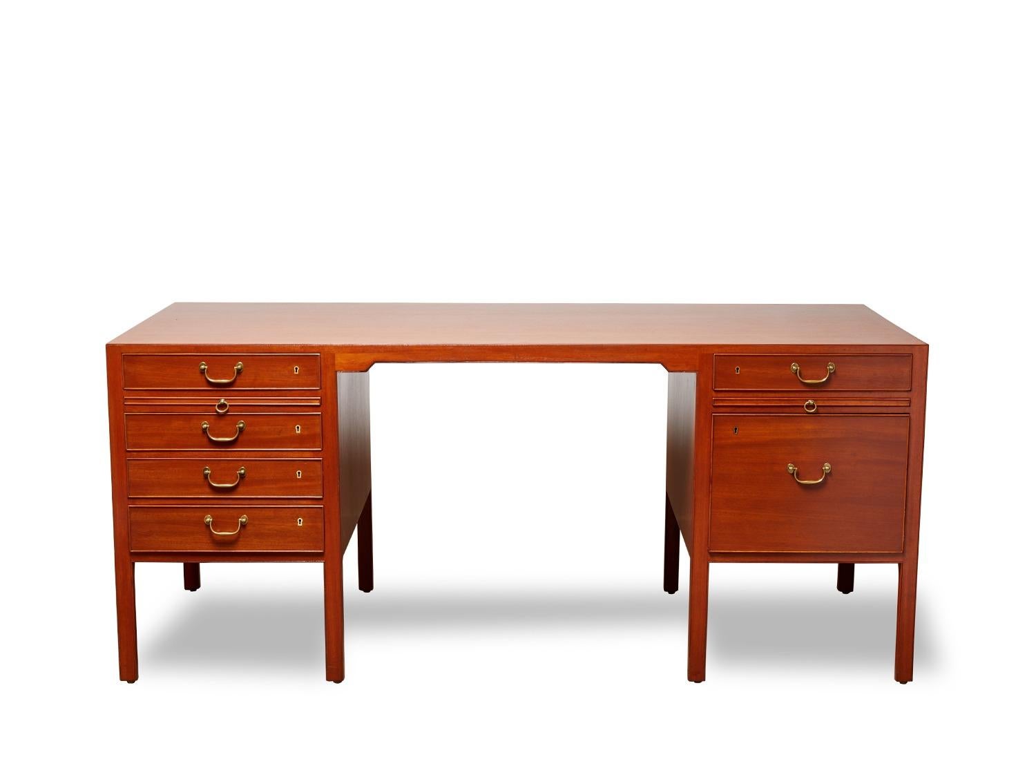 Description: Freestanding desk of mahogany, with eight legs, front with five drawers, back with pullout leaf and two cabinets. Made 1950–1960s by cabinetmaker A.J. Iversen.
Designer: Ole Wanscher
Condition: Wear due to age and use. Later hinges on