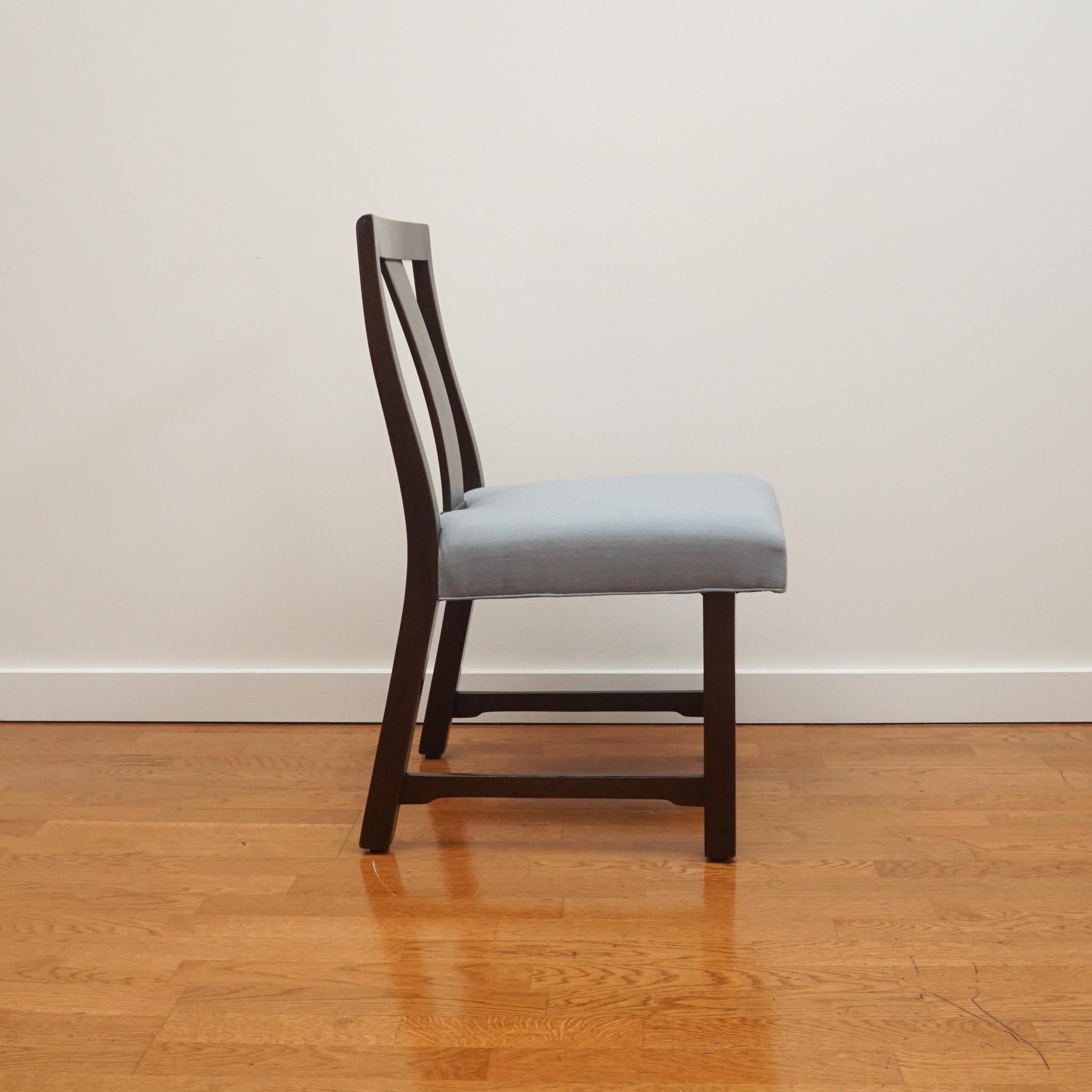 The armless dining chair, shown here, is attributed to Edward Wormely for Dunbar. Featuring a splat back support with slightly cantilevered seat front, the mahogany armless dining chair is one of four available. 

