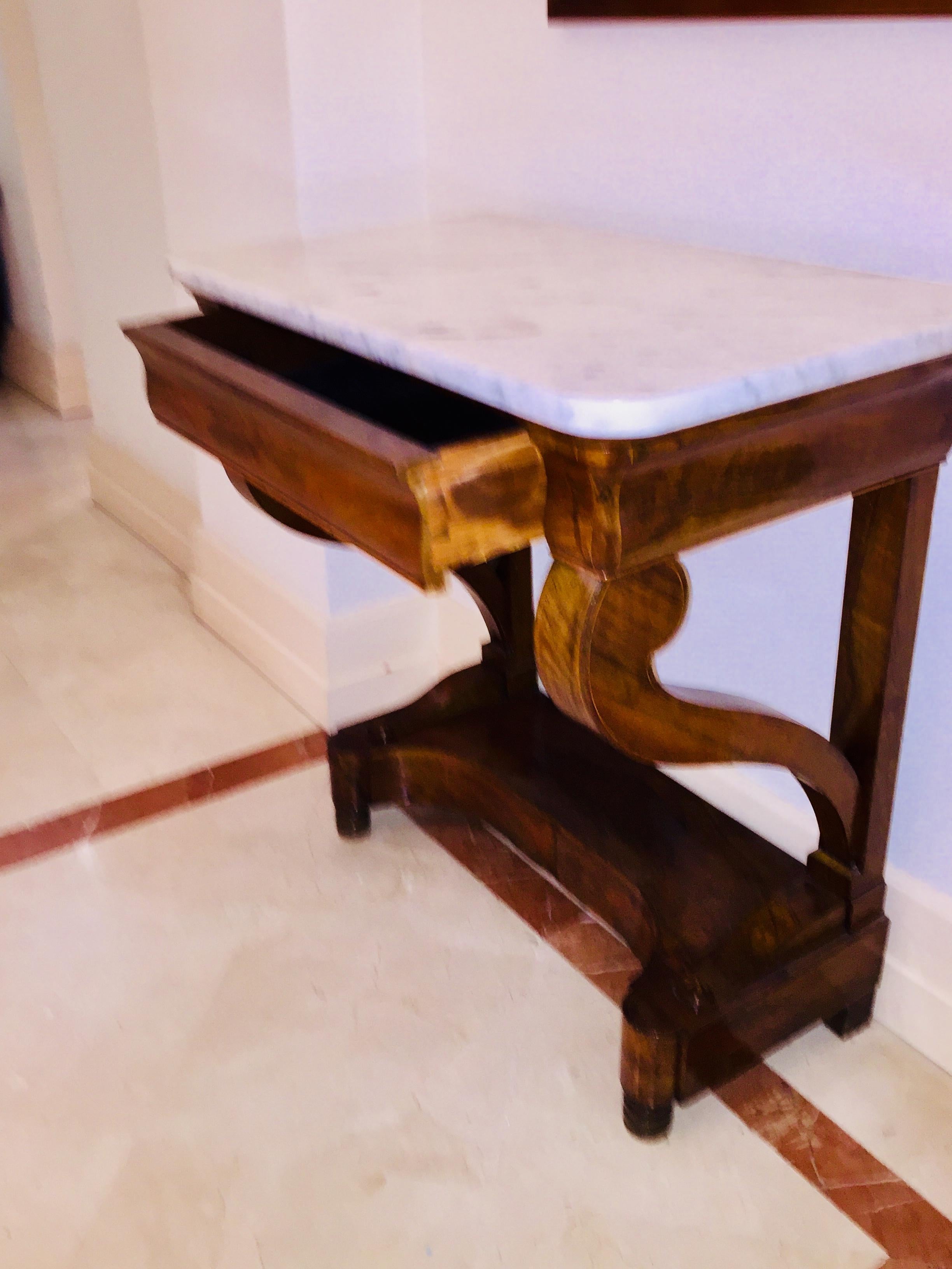 Mahogany Directoire Restauration French marble-top console table.
The size makes this piece easy to use in any place.
Details, carved Palmettes on the base, lemon tree filets inlayed are interesting and refined.
The design of the two legs is