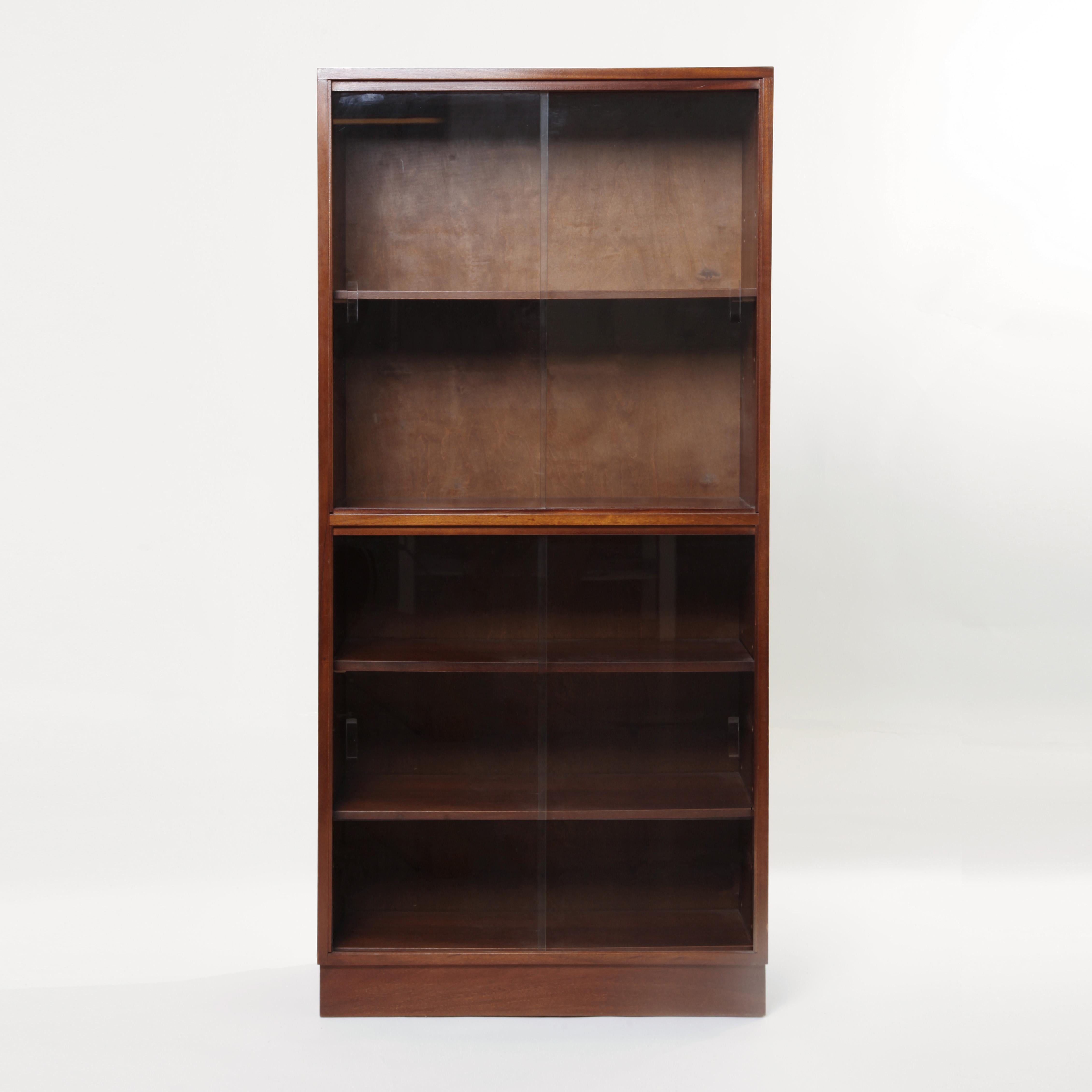 A mahogany display cabinet or bookshelf. Fully fronted glass sliding doors and wood shelves. Original label on the back made in London.