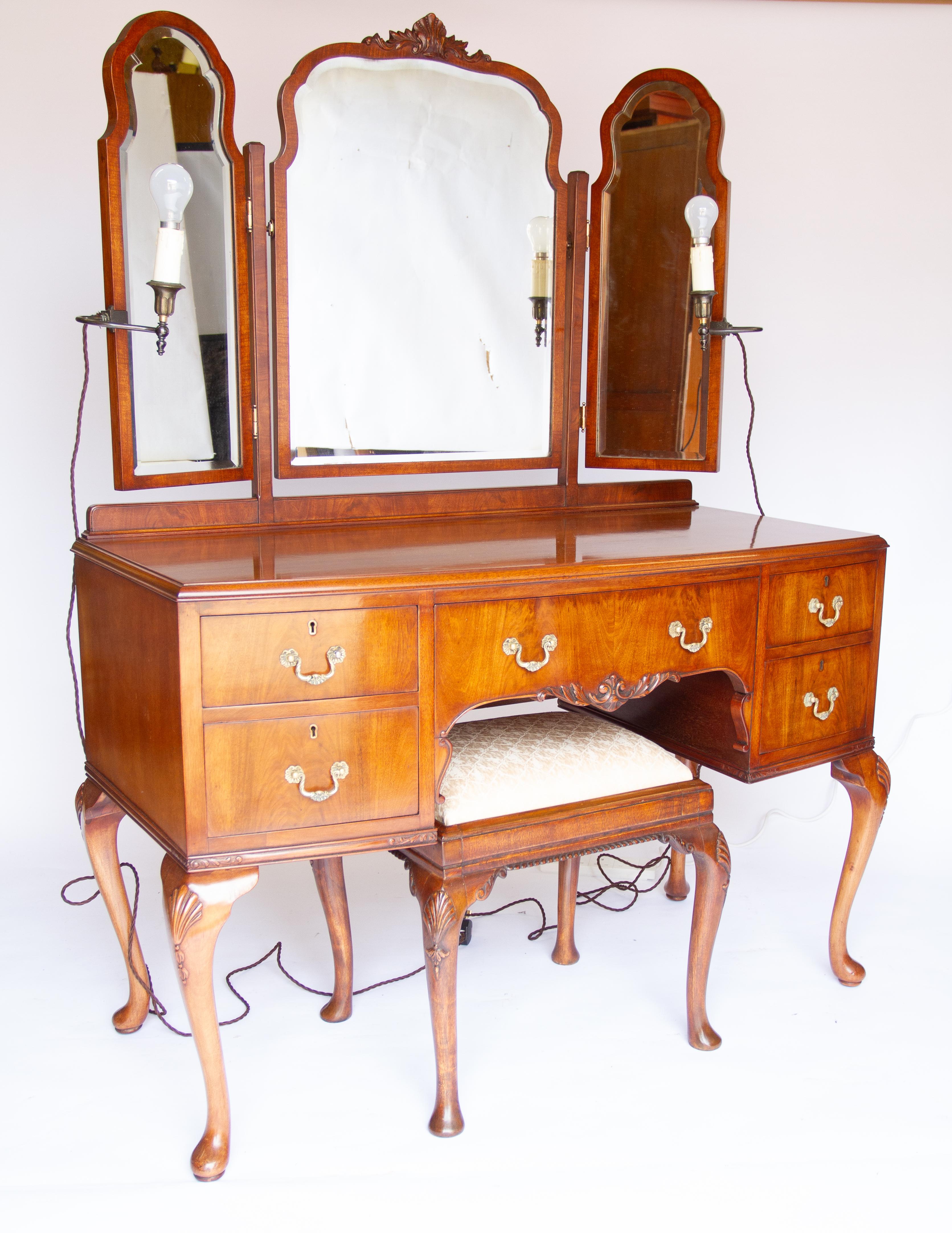  Mahogany Kneehole  Dressing Table with Dressing Stool circa 1930s
Fixed Triple Mirror with Bevelled mirror glass. 
Swivel arched centre mirror with carved shell detail on top
pair hinged side mirrors, with pair cast white metal electric lamps on