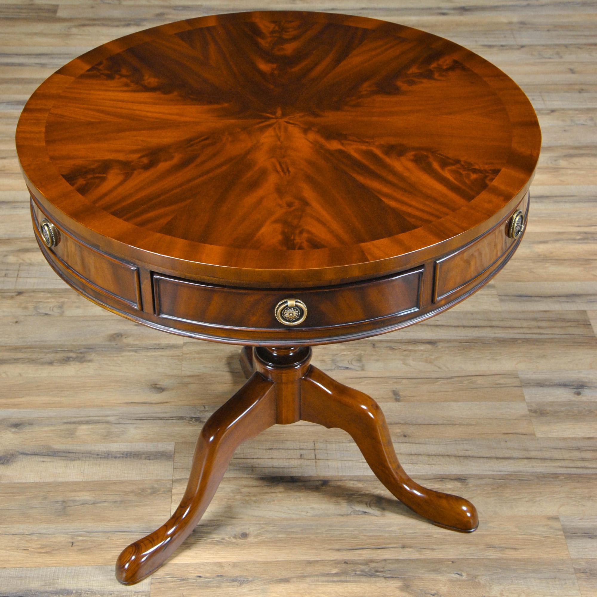 Our Queen Ann style Mahogany Drum Table is a smaller drum table that makes a great accessory item. The Mahogany Drum Table as produced by Niagara Furniture features three dovetailed drawers, beautiful banded top, designer hardware, an urn shaped