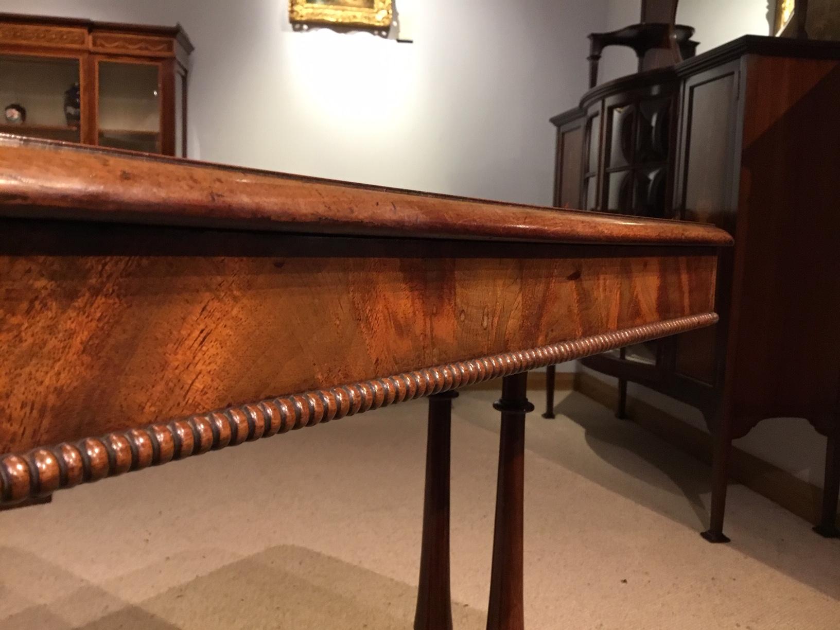 A mahogany early Victorian period antique occasional table. Having a rectangular top veneered in beautifully figured mahogany and with a concealed cedar lined drawer, supported on four elegant turned mahogany columns with a mahogany stretcher and