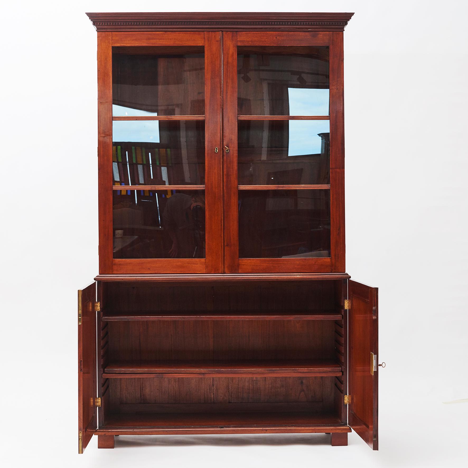 Empire display cabinet from the Danish West Indies (or today known as The Virgin Islands), circa 1810.
This beautiful solid Cuba mahogany cabinet features a top cabinet with double pane glass doors and a lower section with pair of doors.
The