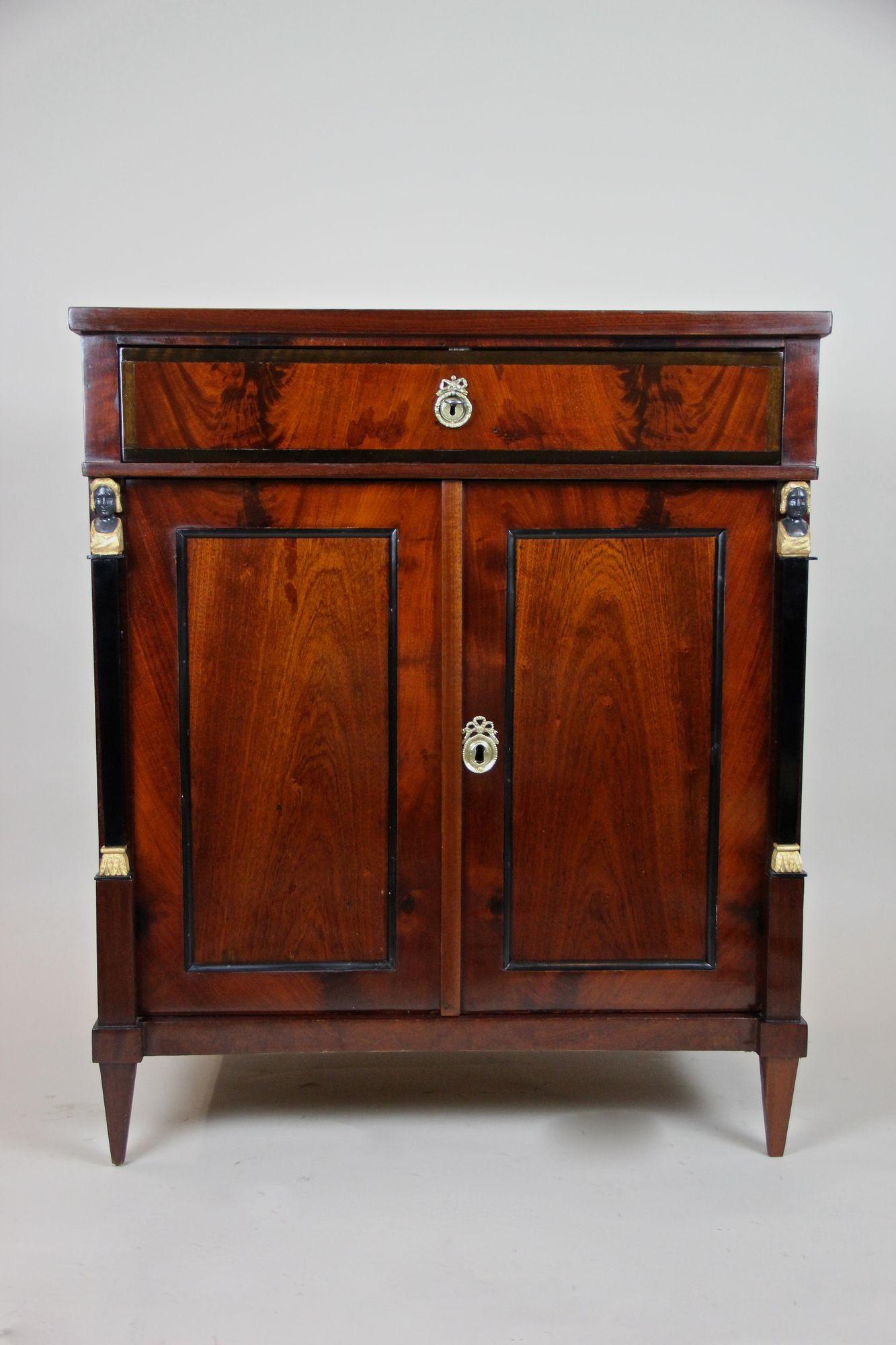 Bemerkenswerter Mahagoni-Kommode/Halbschrank aus dem frühen 19. Jahrhundert aus der späten berühmten Empire-Periode in Deutschland um 1815/20. Die geradlinige, zeitlose Form in Kombination mit dem außergewöhnlichen, spiegelbildlichen Mahagonifurnier