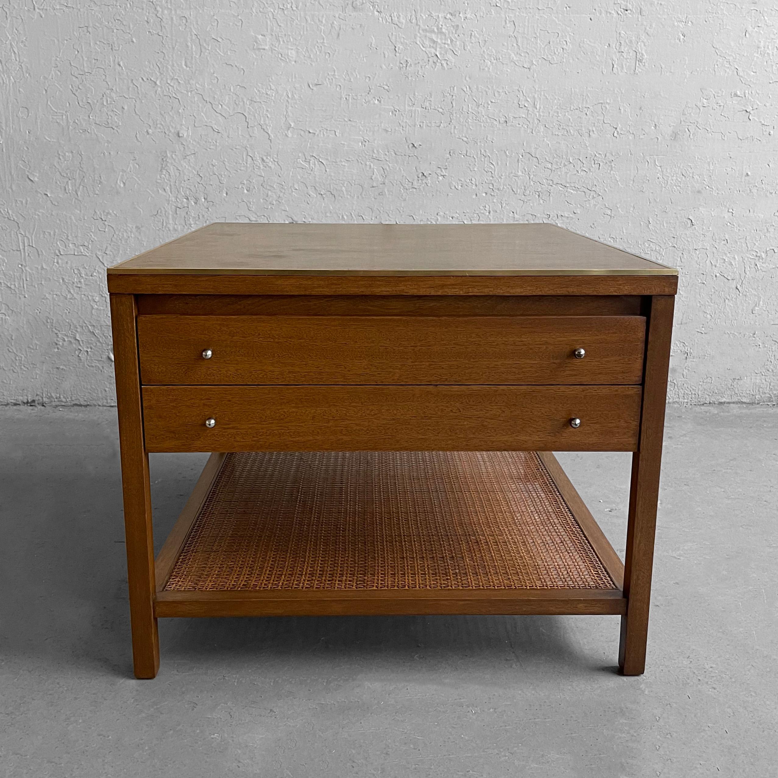 Mid-Century Modern, bleached mahogany, end table by Paul McCobb for Calvin, Irwin Collection features a leather top with brass trim, caned lower shelf and nickel plated brass pulls. The caned lower level measures 7 inches height. The two drawers are
