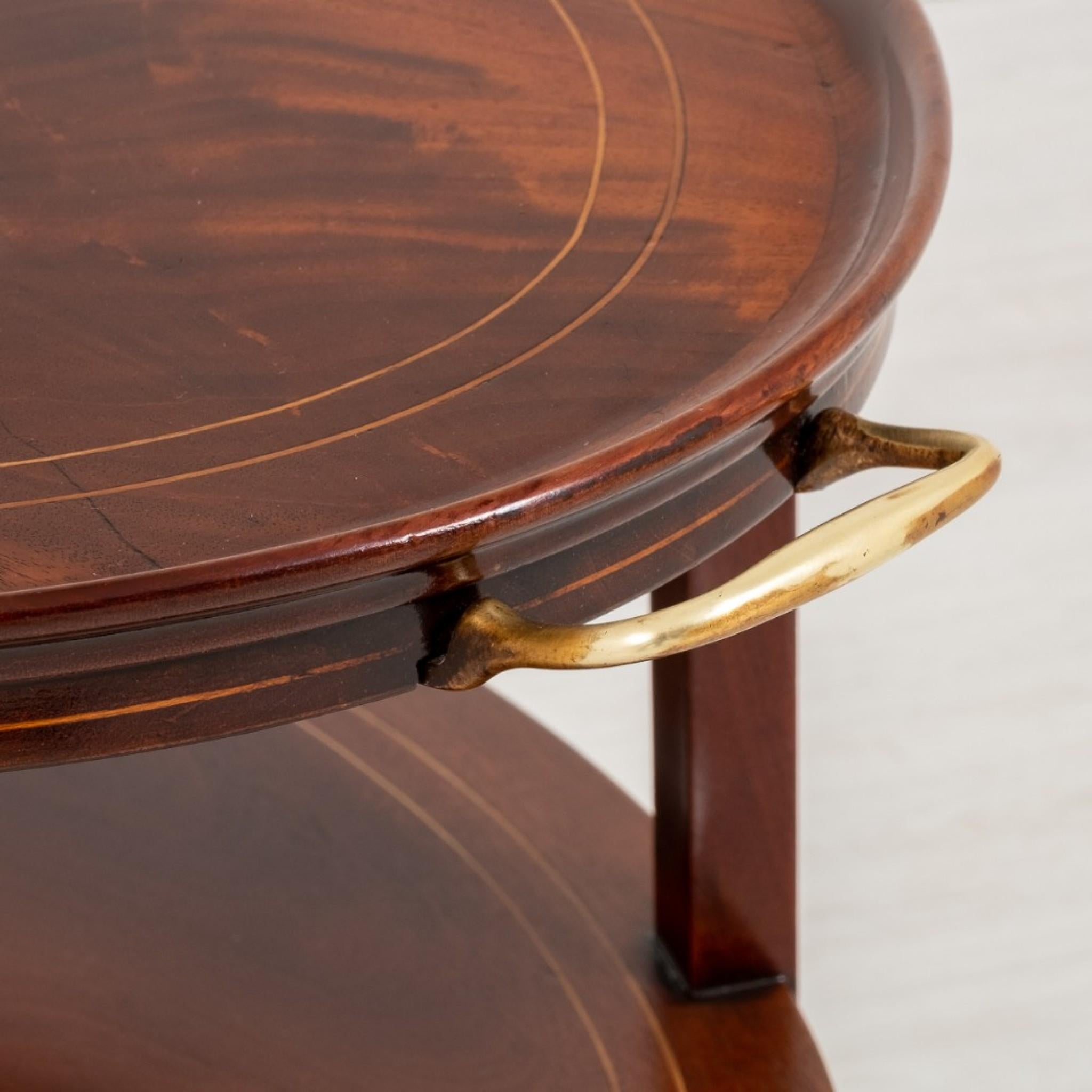 Etagère ovale en acajou marqueté.
Circa 1900
Pieds fuselés avec incrustations en buis.
Les tablettes supérieure et inférieure hautement figurées présentent également des incrustations en buis.
Etagère complète avec poignées de transport en laiton.