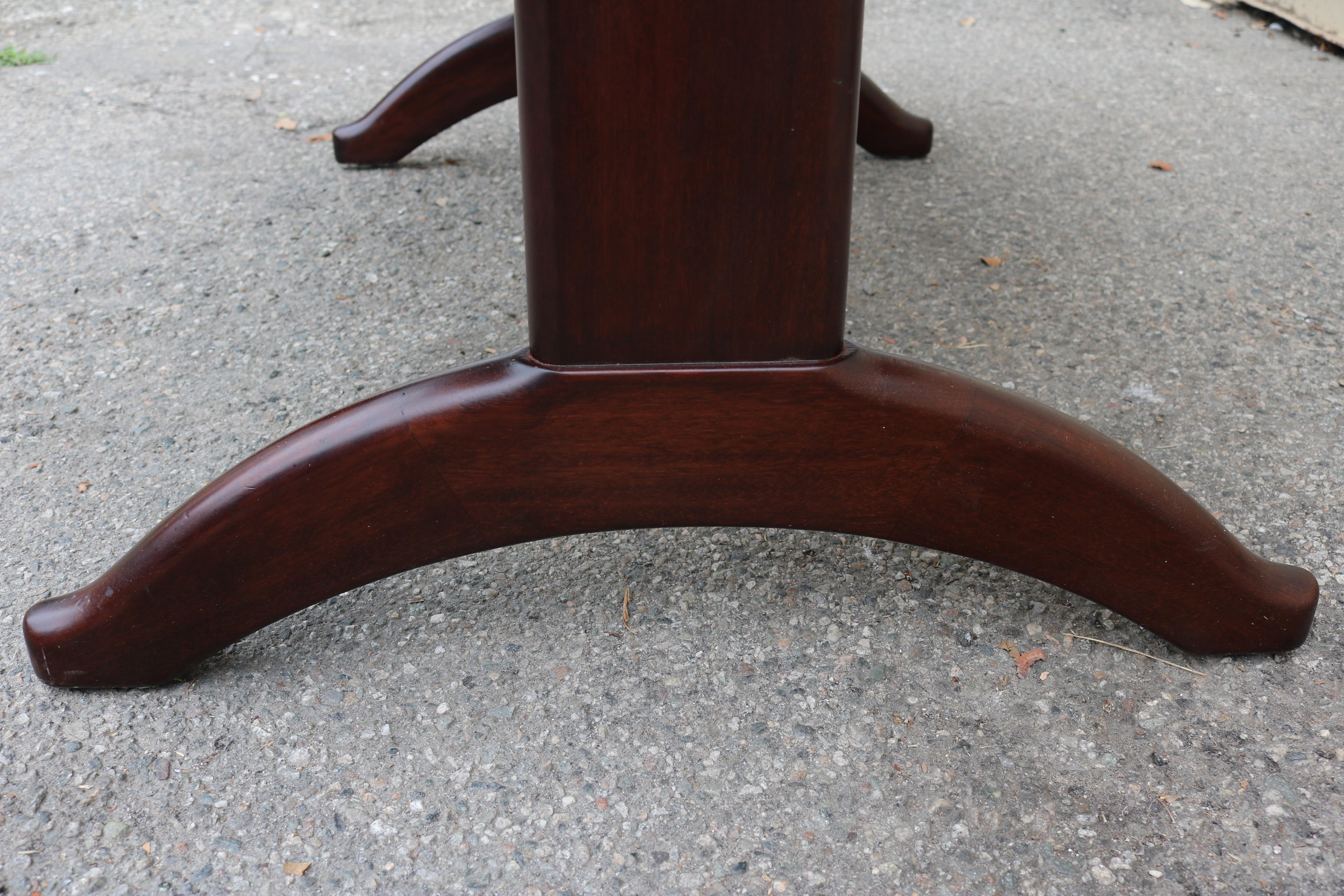This comfortable dining table is made of mahogany and features stately, rounded edges. Its legs sport an elegantly curved design and are connected by a stretcher. It has two leaves measuring 40