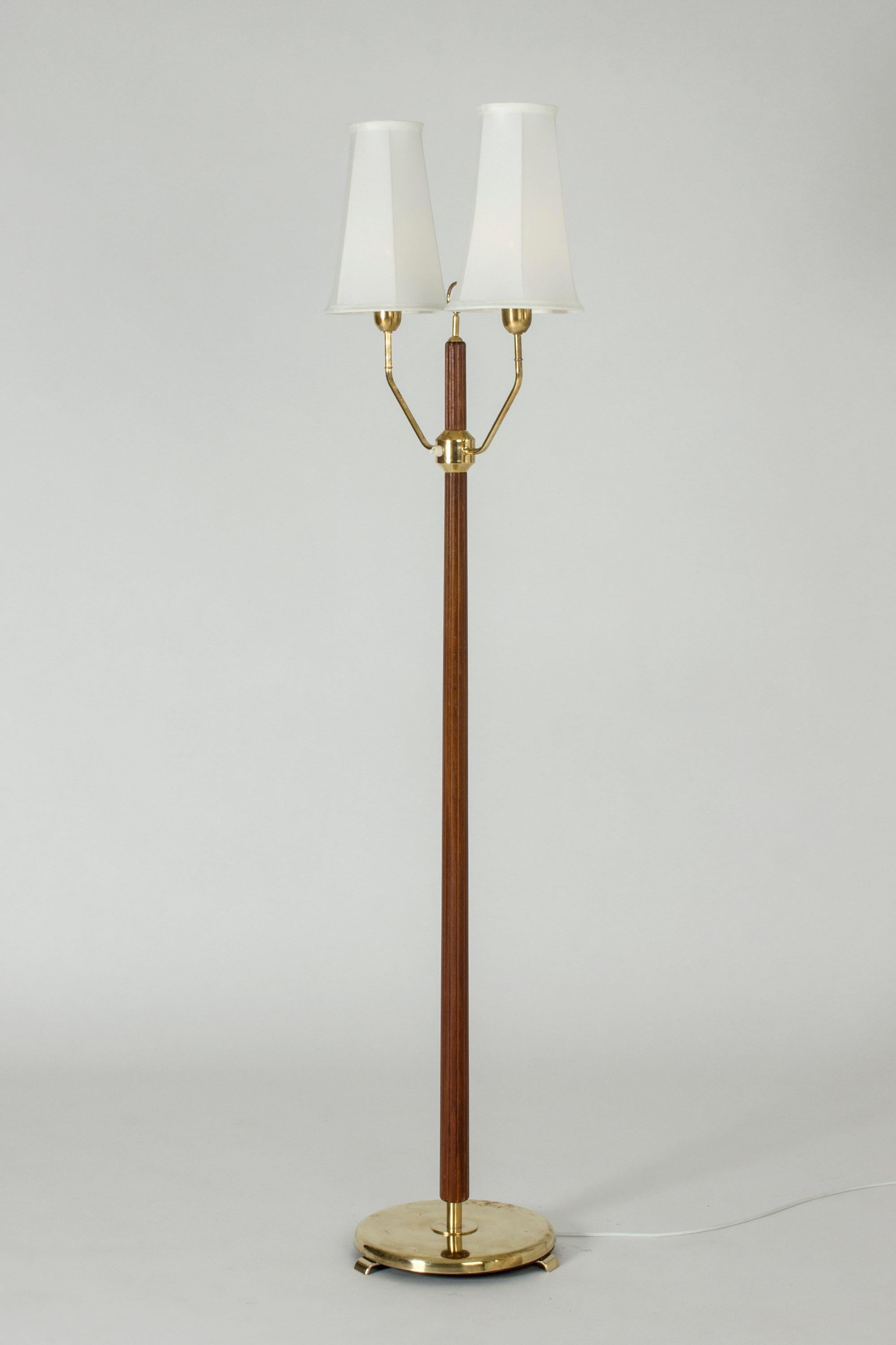 Elegant floor lamp with two shades by Hans Bergström. Made from brass with a mahogany stem embossed with stripes along the length. Decorative hoop detail between the shades.