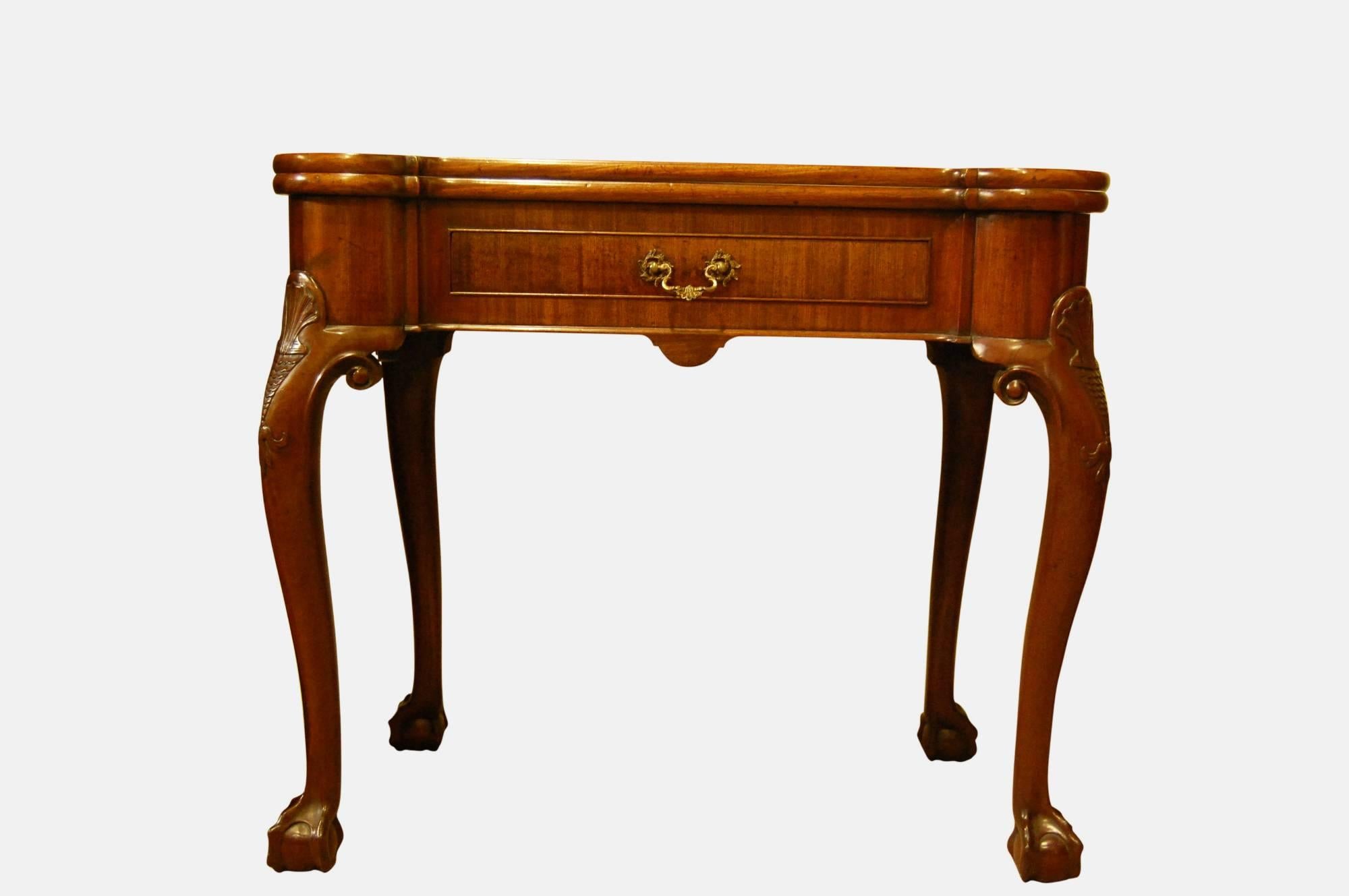 George III Irish mahogany foldover table

Turret corners, centre frieze drawer 

Cabriole legs hipped and carved with fish scale above pendant bell flowers

Ball and claw feet.
 