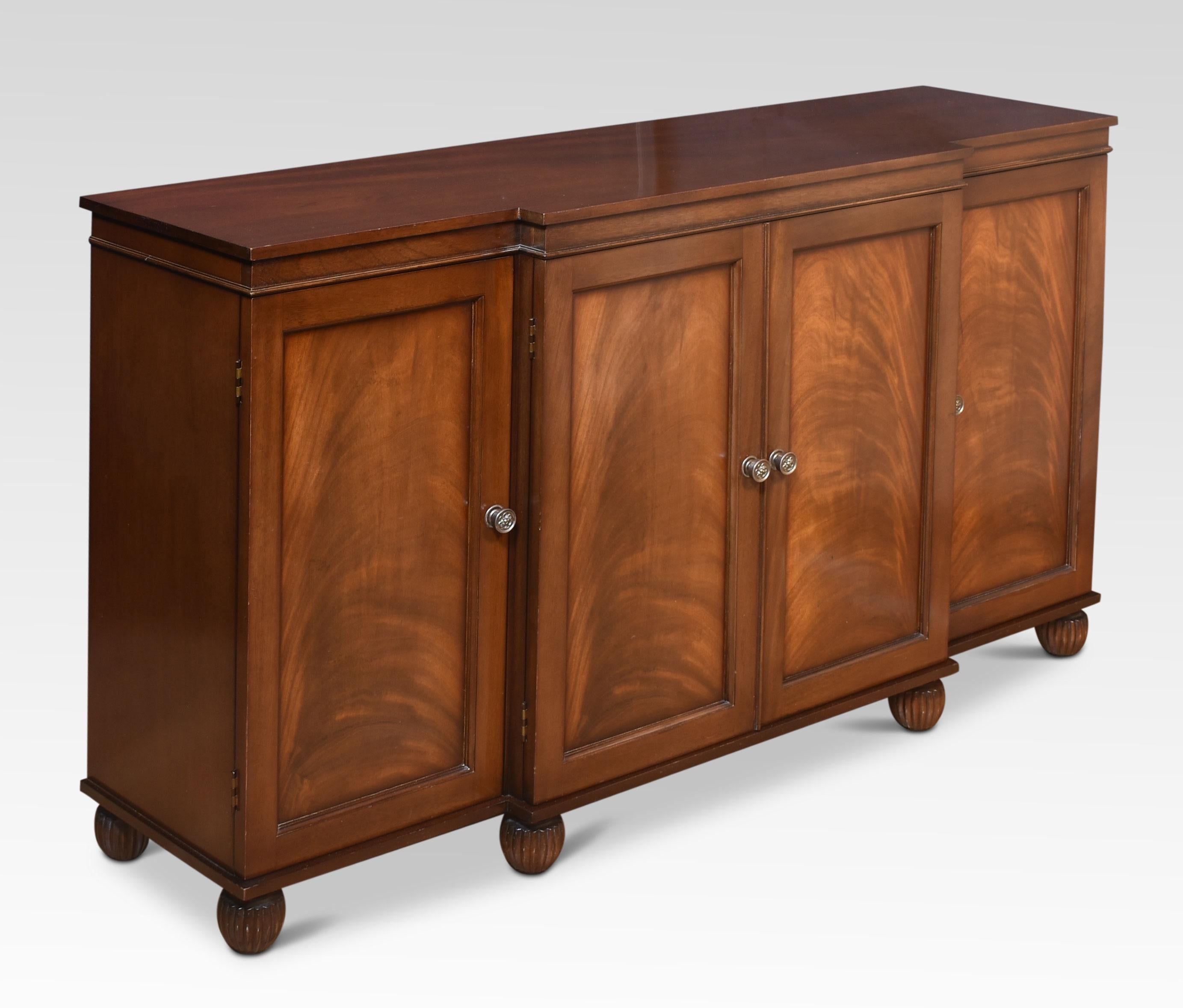 Mahogany sideboard the large rectangular mahogany breakfront top above four flame mahogany panelled doors opening to reveal the adjustable shelved interior and baize lined cutlery drawer. All raised up on turned feet.
Dimensions
Height 35