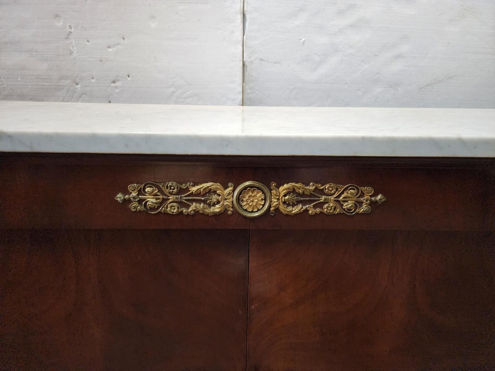 Attributed to Nordiska, this mahogany sideboard features bronze mounting on marble in a French Empire style. 