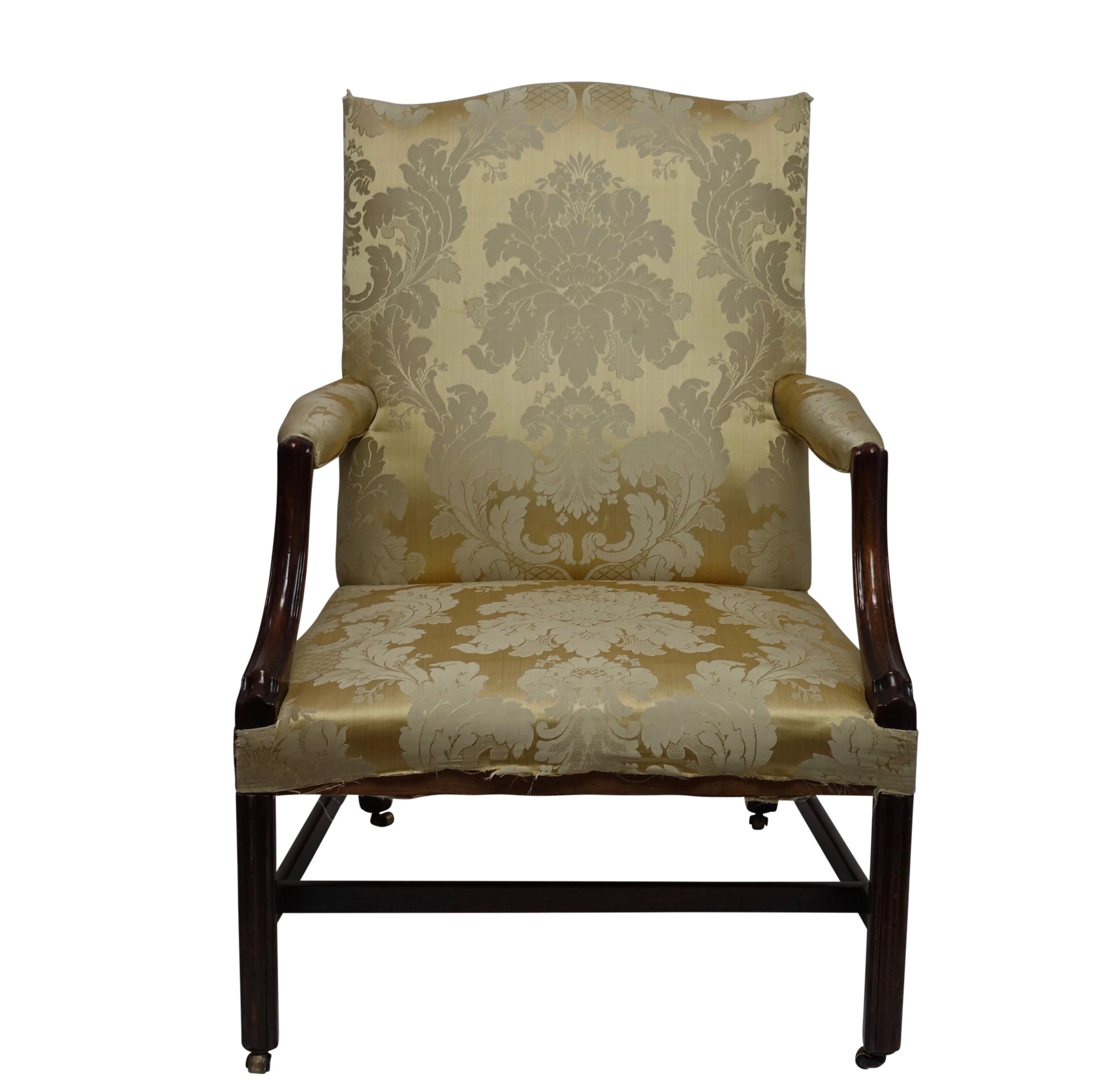George III style Gainsborough mahogany library armchair. Having typical of the period generous proportions with carved arms, chamfered legs and original brass casters. English, Circa 1760.