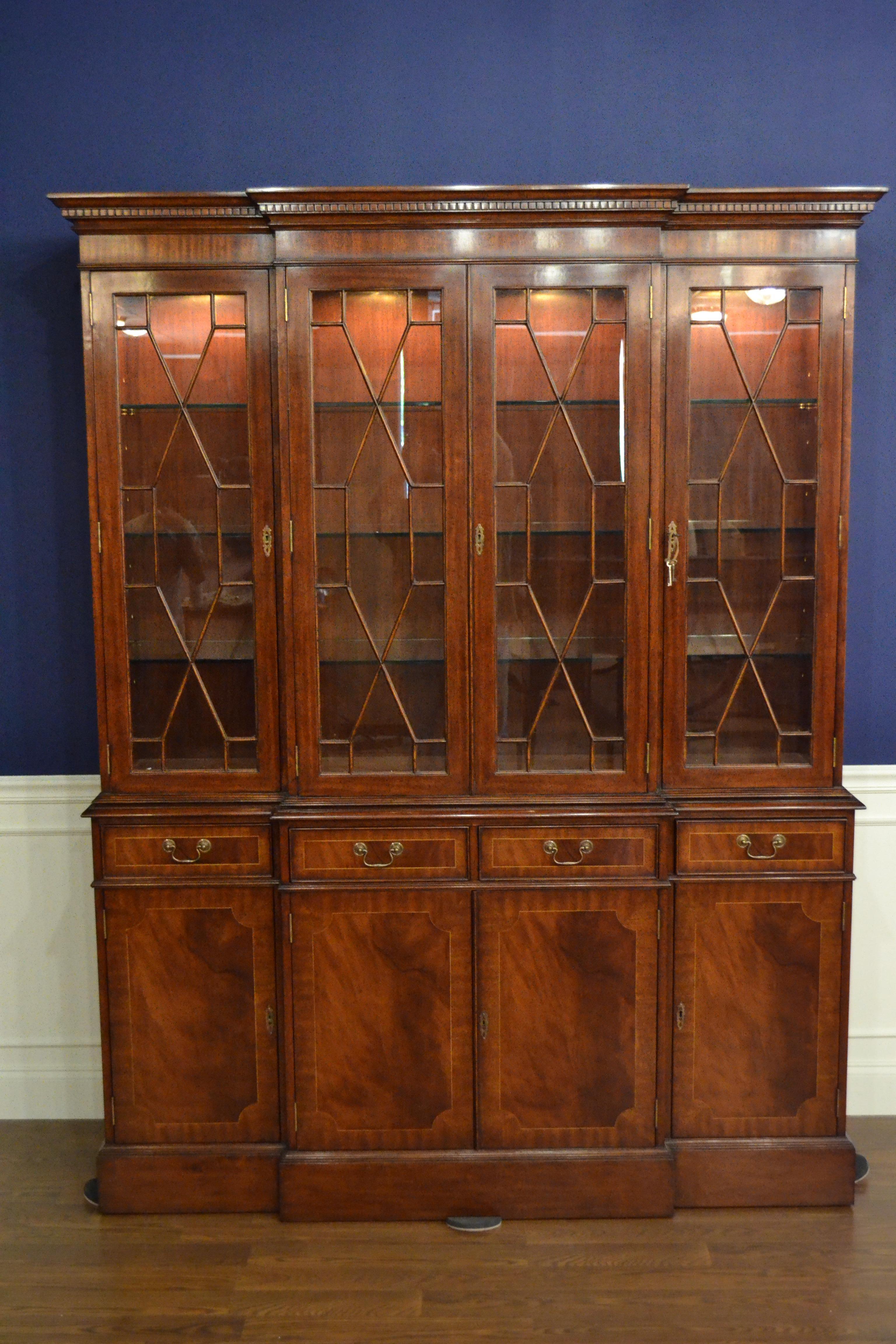This a traditional mahogany breakfront bookcase or china cabinet with four doors by Leighton Hall. It features four bottom doors with swirly crotch mahogany fields and straight grain mahogany borders. The top four doors feature grills with