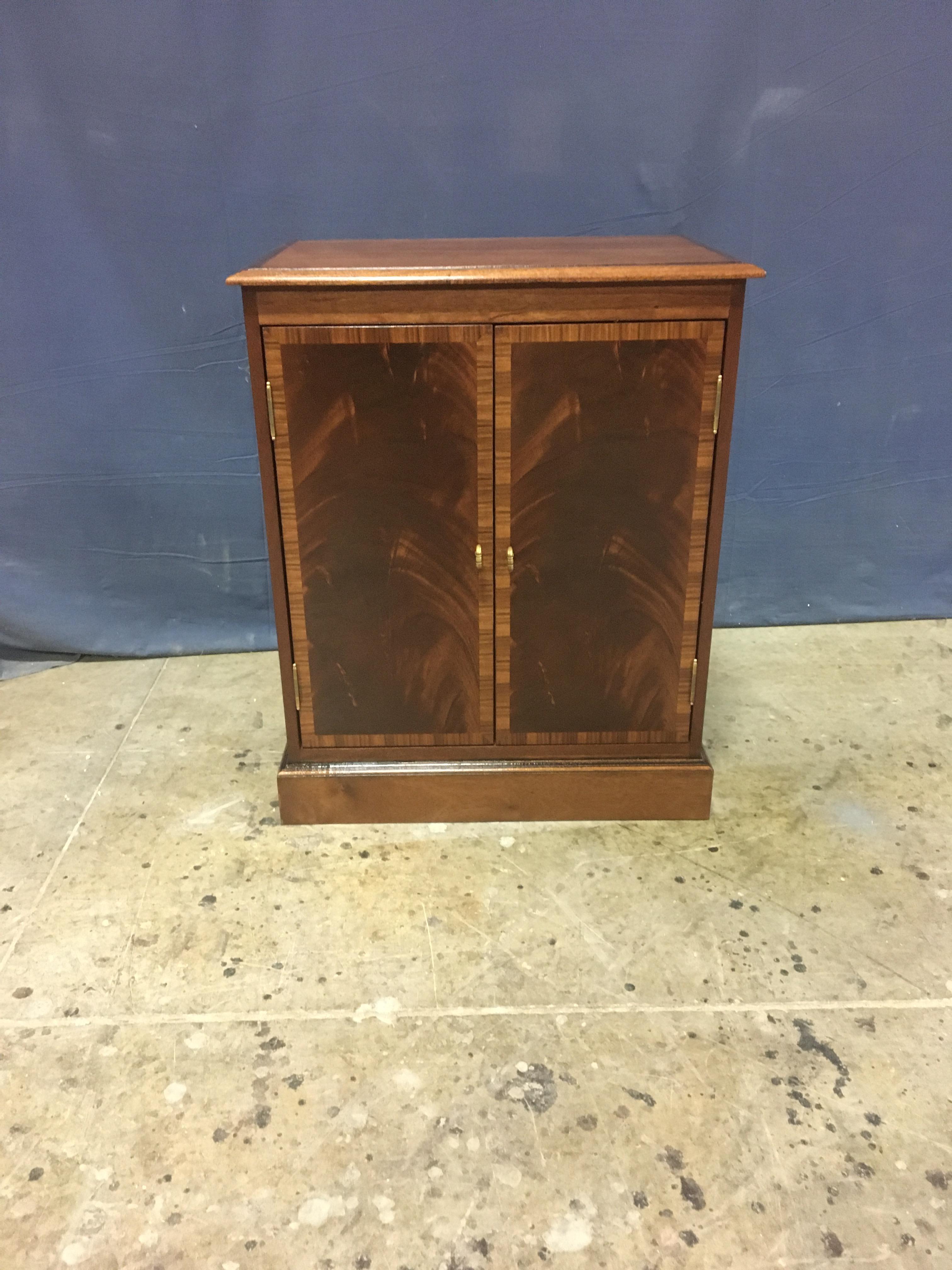 This is made-to-order traditional mahogany two-door cabinet made in the Leighton Hall shop. It is ideal to be used as a small buffet, hall cabinet/credenza or foyer cabinet. It features two doors with swirly crotch mahogany fields and a Pau Ferro