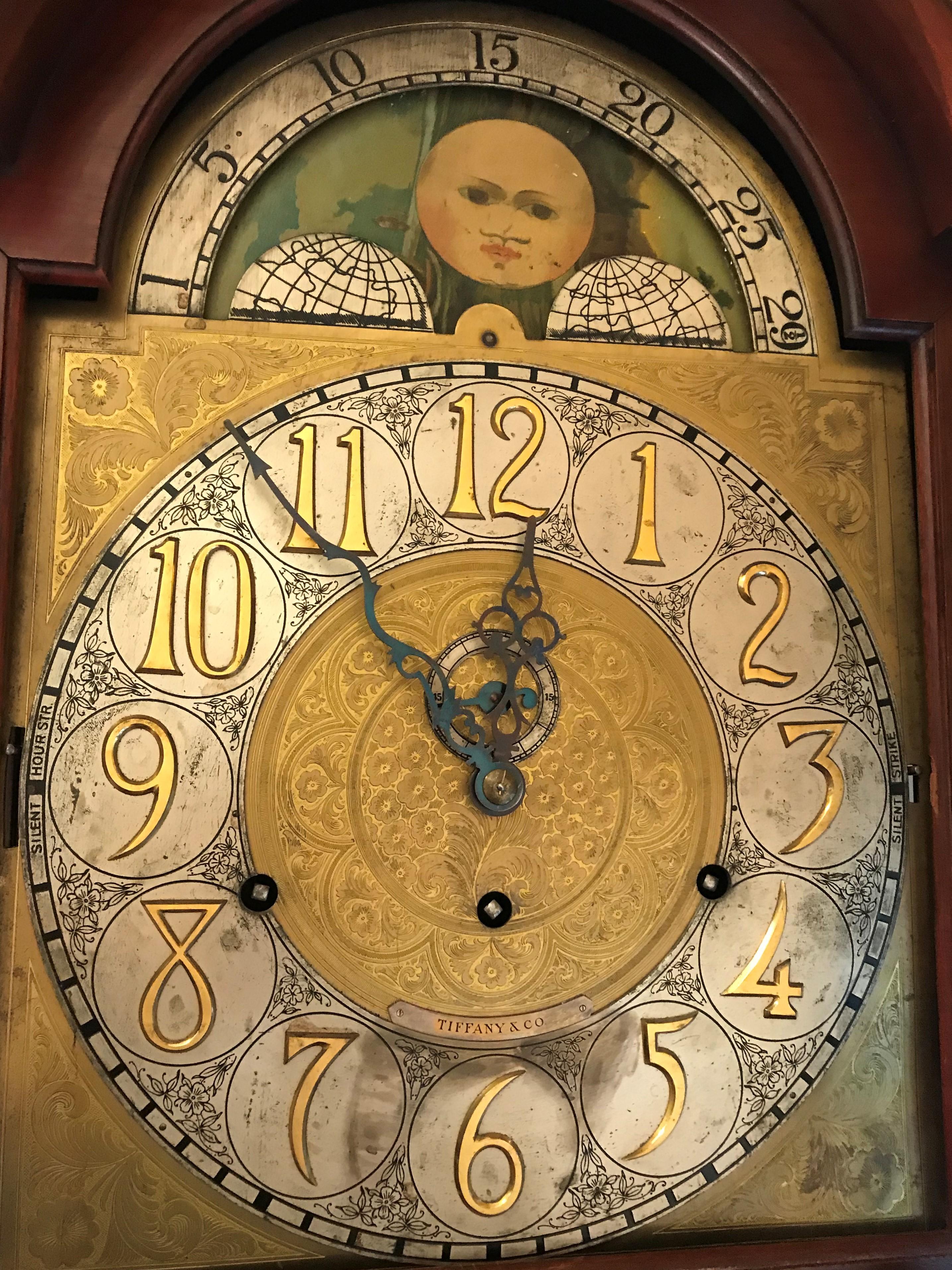 Grandfather clock. Mahogany case. Westminster Chimes, circa 1900-1910.

Face stamped with retailer Tiffany & Co. Phases of moon lunar dial with scene of ships and house in landscape.

Strikes on hour, half hour, and quarter hour. Westminster