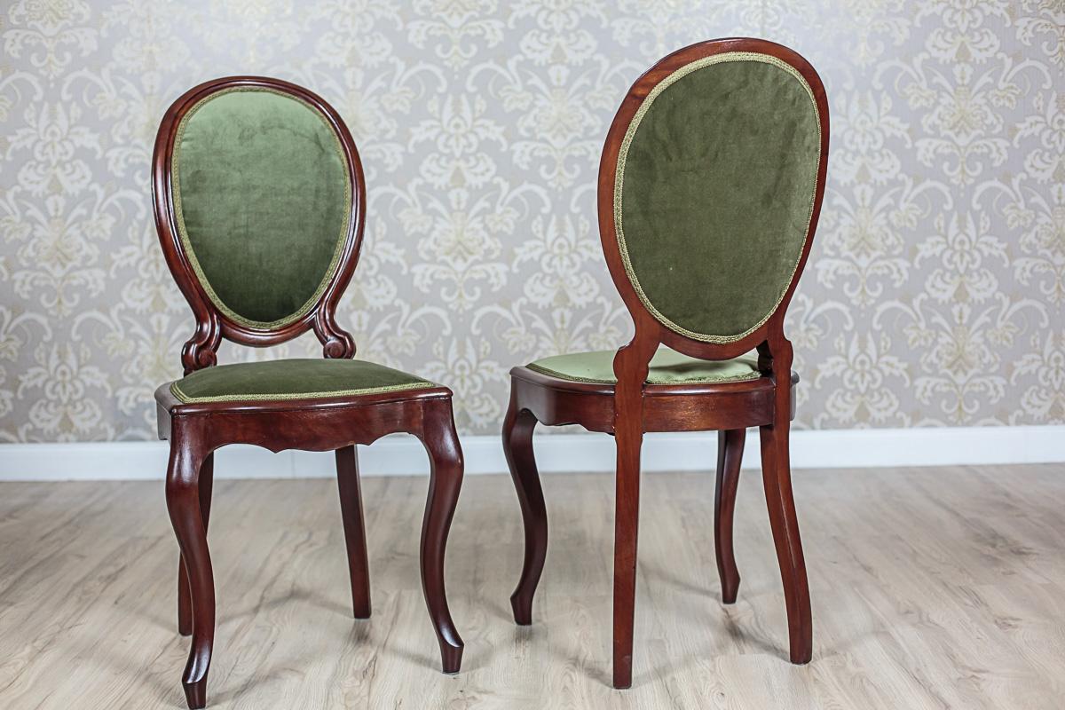 Chairs with upholstered seats and backrests, made in mahogany wood. The front and side rails are profiled. The front legs are bent in the cabriole manner. The backrests of the chairs are in a medallion shape and are supported on a frame of volute