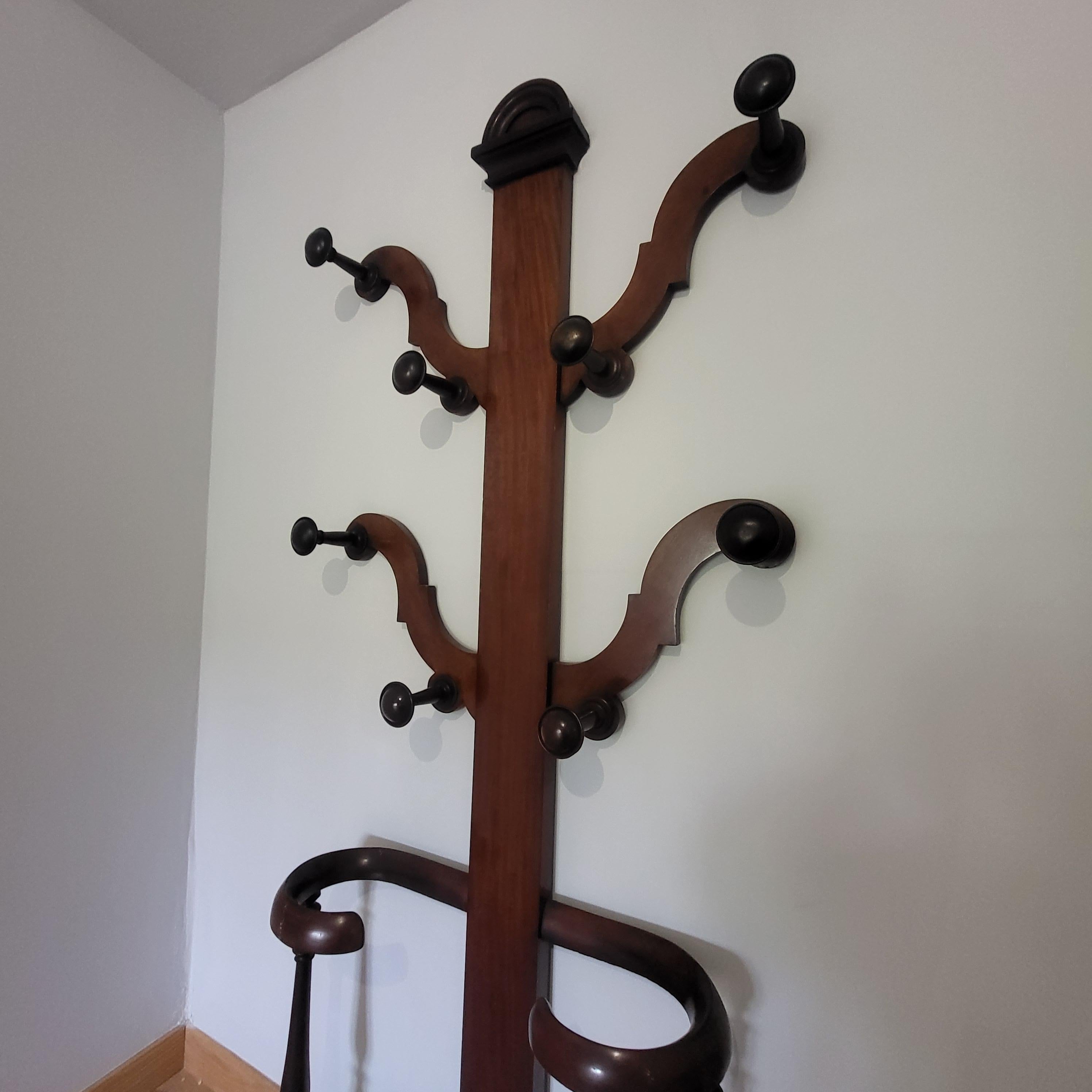 Explore the elegance of history with our Late 19th-century Mahogany Hall Tree. This authentic piece, crafted from solid mahogany, features original turned hooks, a round pediment top, and gracefully shaped arms, reflecting the sophistication of its