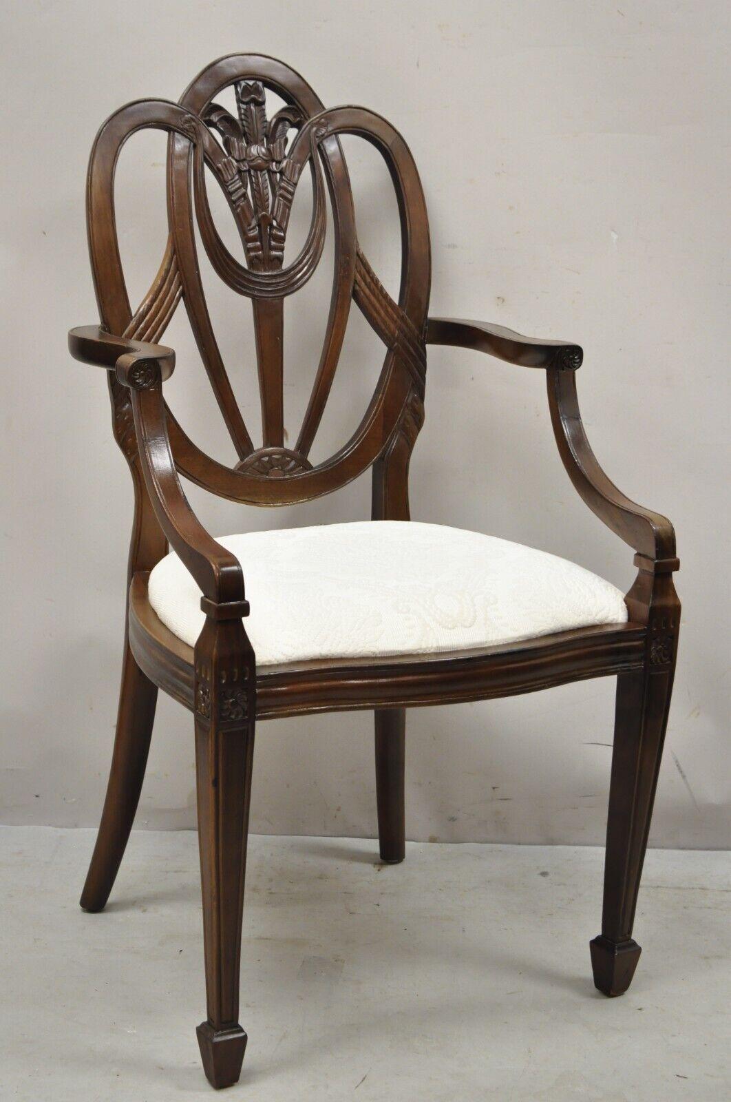 Mahogany Hepplewhite style prince of wales plume carved dining arm chair. Item features a plume carved back splat, solid wood frame, tapered legs, great style and form. Circa Late 20th Century. Measurements: 39.5