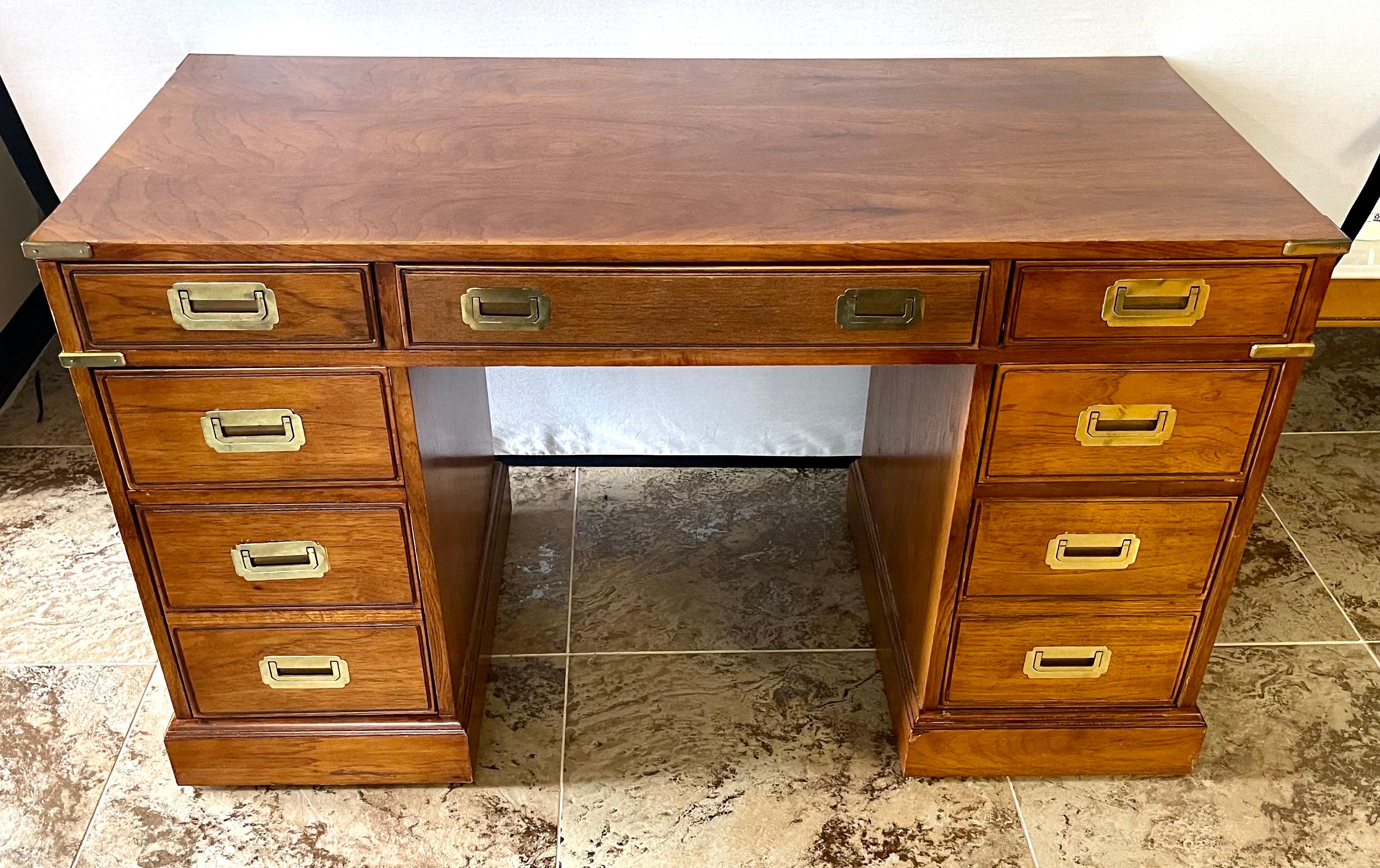 Handsome mahogany kneehole campaign partners desk with brass corner brackets and recessed brass drawer pools. With nine dovetailed drawers for with plenty of storage. Finished on the back it can also float in a room. By National Mt. Airy. A