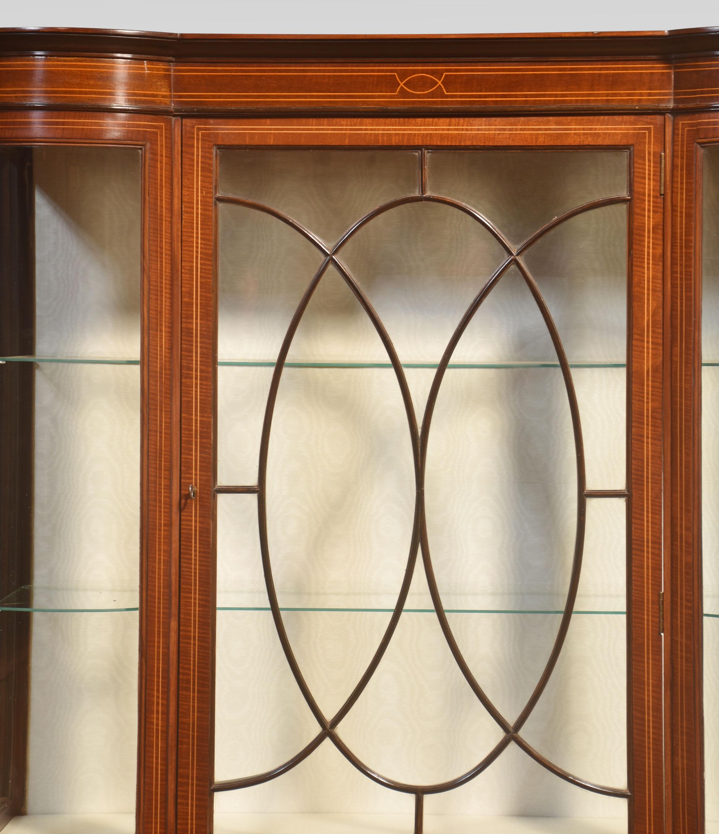 Mahogany display cabinet. Having a large central glazed door enclosing glass shelves and a watermark silk upholstered interior, flanked by bowed ends. All raised up on tapering supports.
Dimensions
Height 69.5 Inches
Width 48.5 Inches
Depth 17 Inches