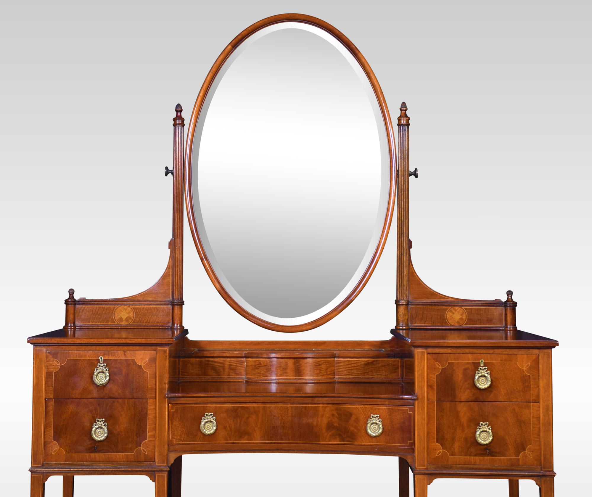 Edwardian mahogany dressing table, the oval bevelled mirror flanked by two reeded supports to the large rectangular top fitted with bijouterie cabinet. To the base section fitted with central drawer having brass tooled handles with two further draws