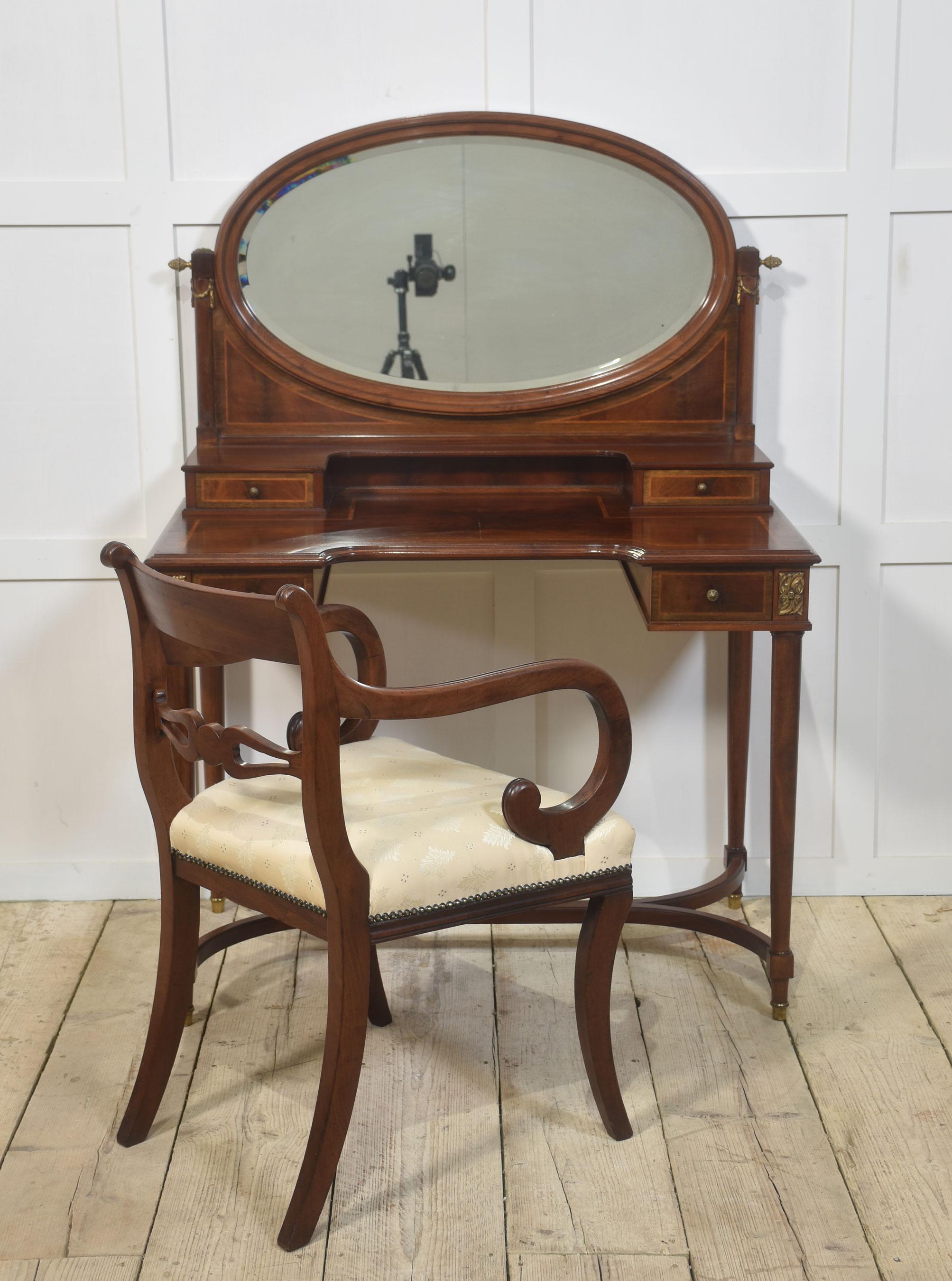 Mahogany dressing table, the oval framed bevelled mirror supported on raised superstructure fitted with two short drawers. To the large rectangular well-figured and inlaid top having moulded edge. Above two further drawers with well-cast brass