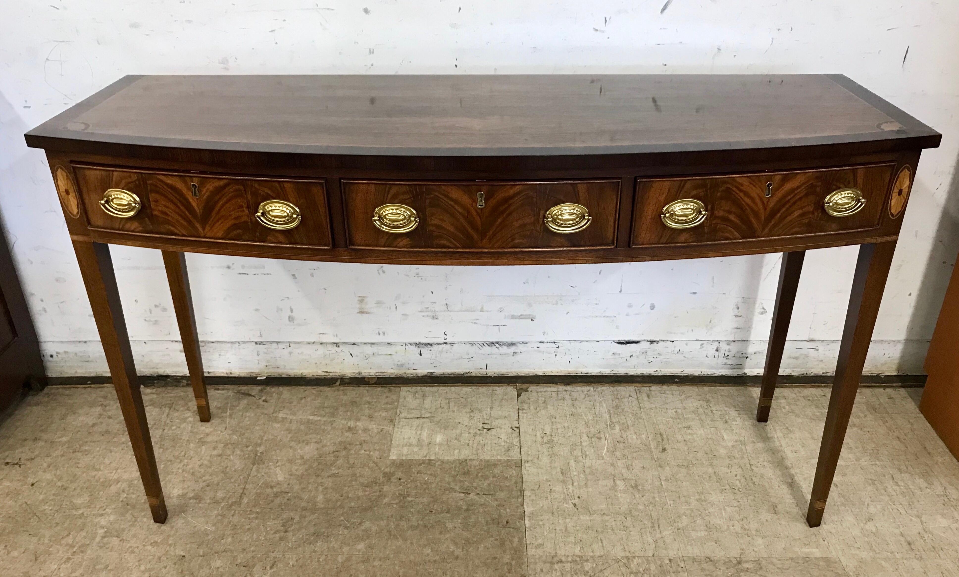 Beautiful flame mahogany sideboard with line and oval inlays. It is remarkably sturdy with three drawers that feature handcut dovetails and brass pulls all on firm square tapered legs. Center drawer is felt lined to store silver flatware.