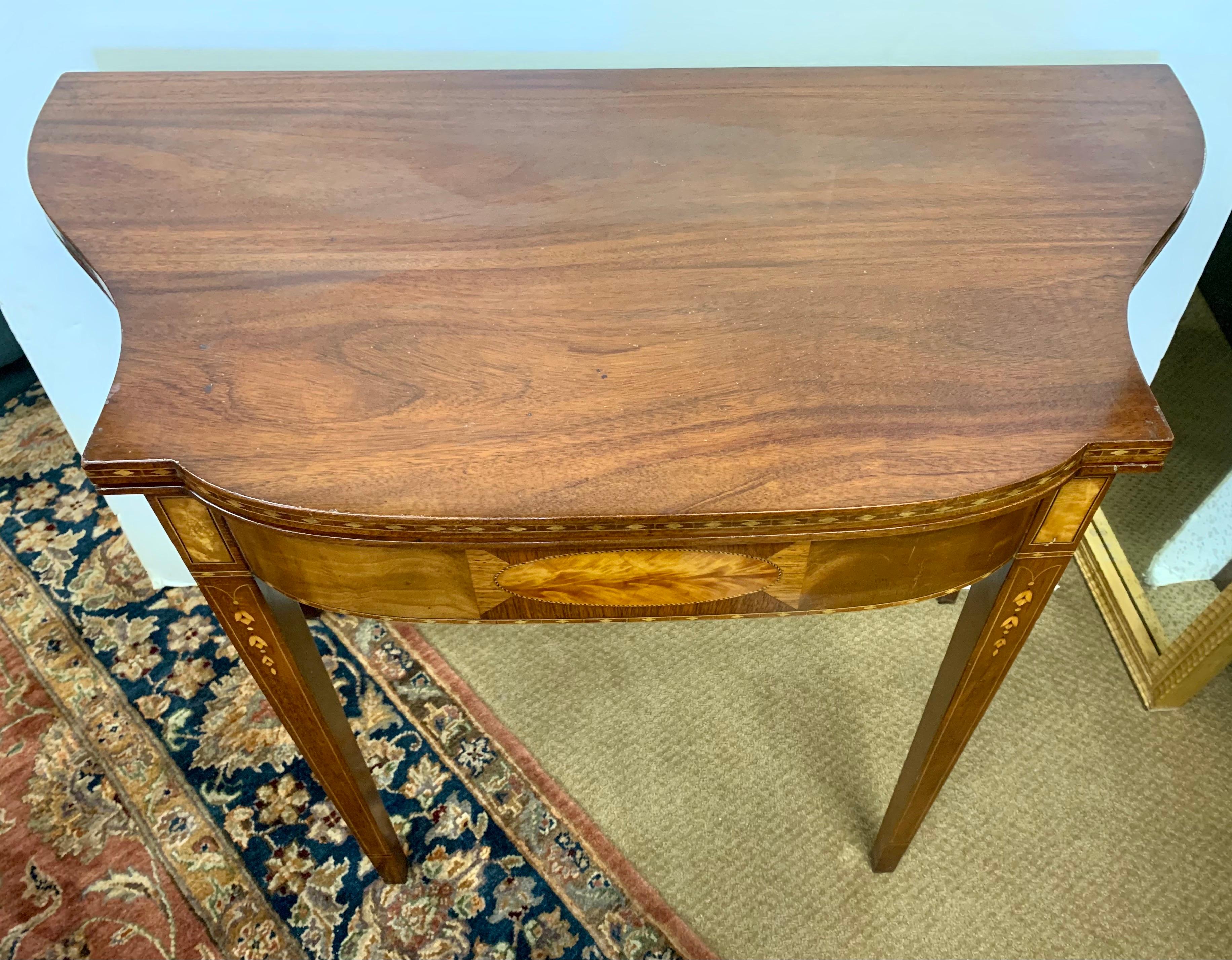 Antique mahogany wood, banded inlaid on the sides supported with four tapered legs with bellflower inlays. The back legs pulls out and the top flips open to make a larger surface.
This table could be used as console or game table.
Open: 35