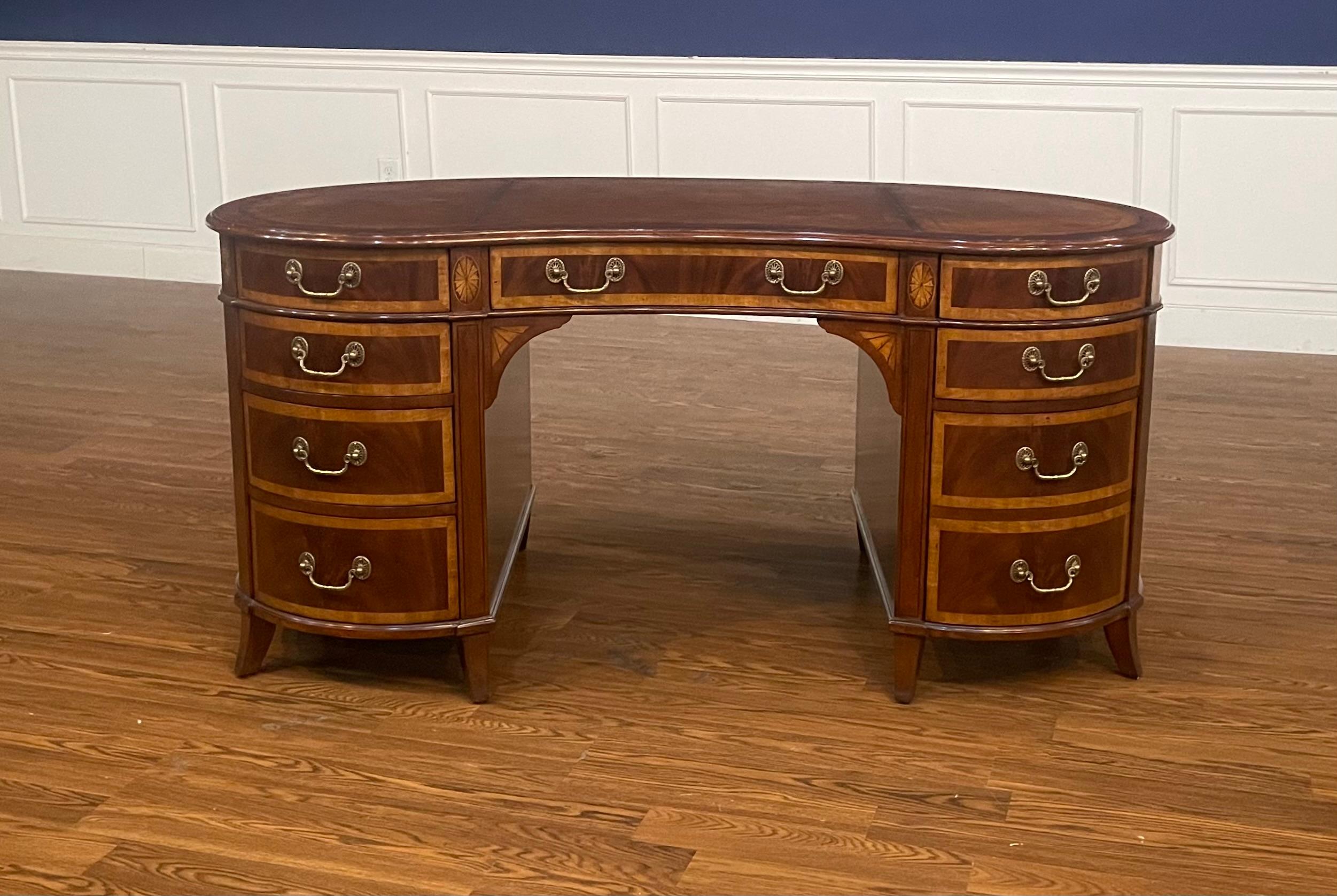 This is a new Hepplewhite style Kidney shaped writing desk. It is ideal for the home office, library, or reception area in a business setting. It features a top of brown leather with gold tooling. Its front, back and side panels and drawers have