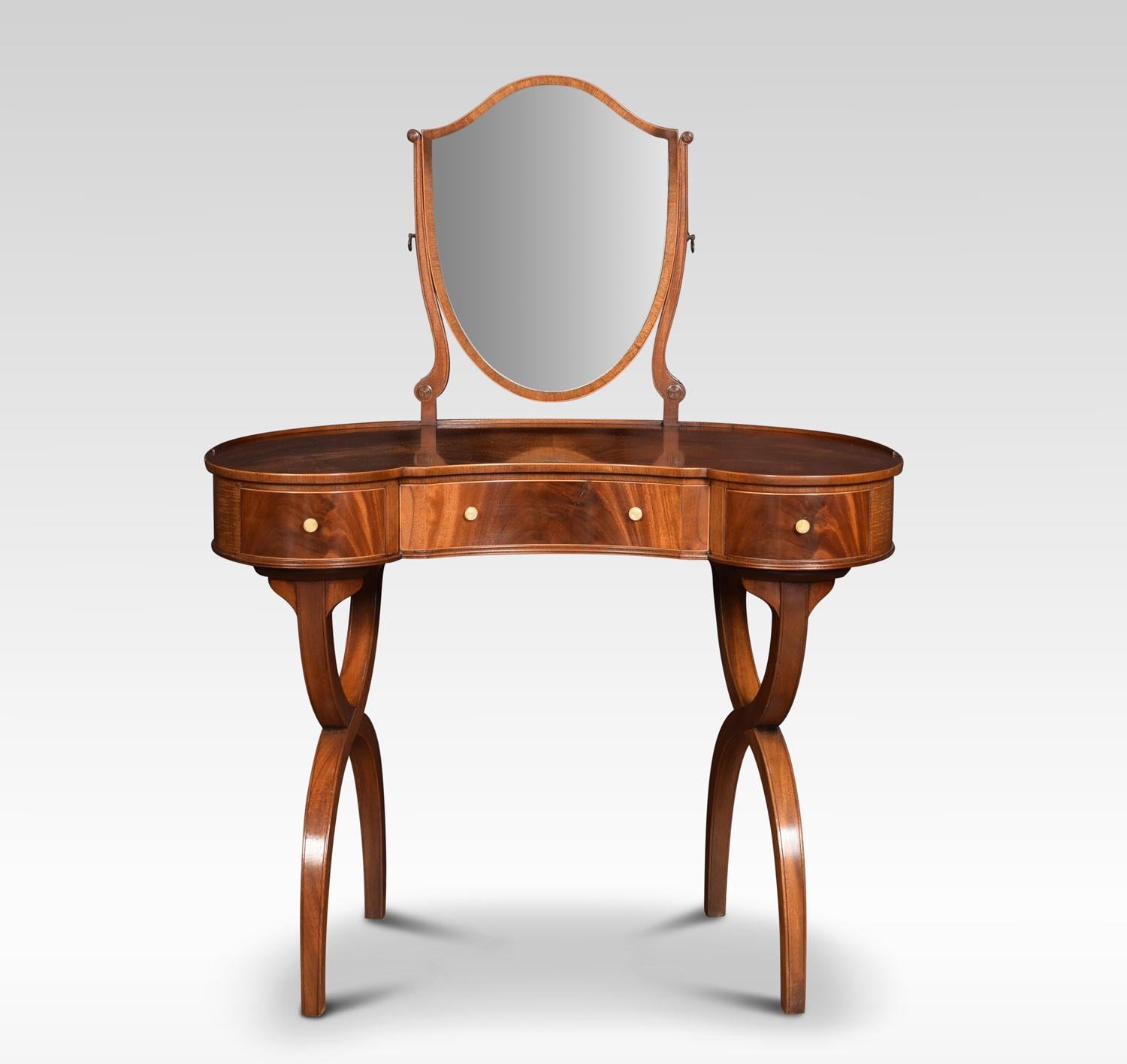 Mahogany kidney shaped lady’s dressing table, the shield shaped adjustable mirror supported on slender mahogany supports. To the well figured kidney shaped top. The dressing table fitted with three freeze draws with knob handles. All raised up on x
