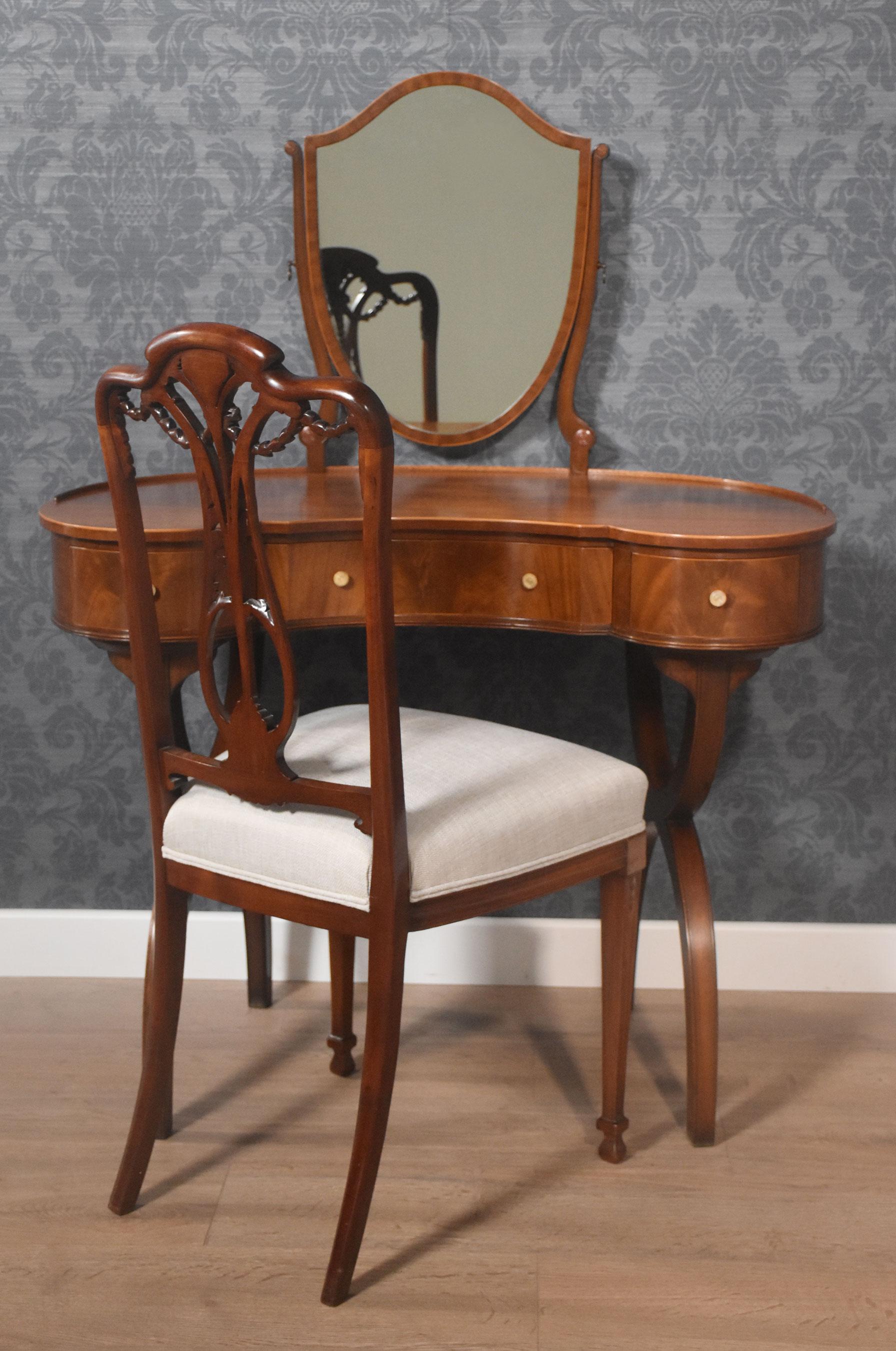 Mahogany kidney-shaped lady’s dressing table, the shield-shaped adjustable mirror supported on slender mahogany supports. To the well-figured kidney-shaped top. To the frieze fitted with three drawers with round handles. All raised up on x-shaped