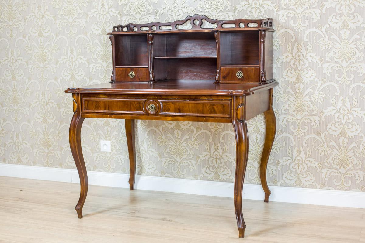 We present you a piece of furniture made of mahogany wood and partially covered in pyramidal mahogany veneer.
This desk is composed of two sections: a bottom one, with a rectangular top supported on cabriole legs, and an upper, removable add-on