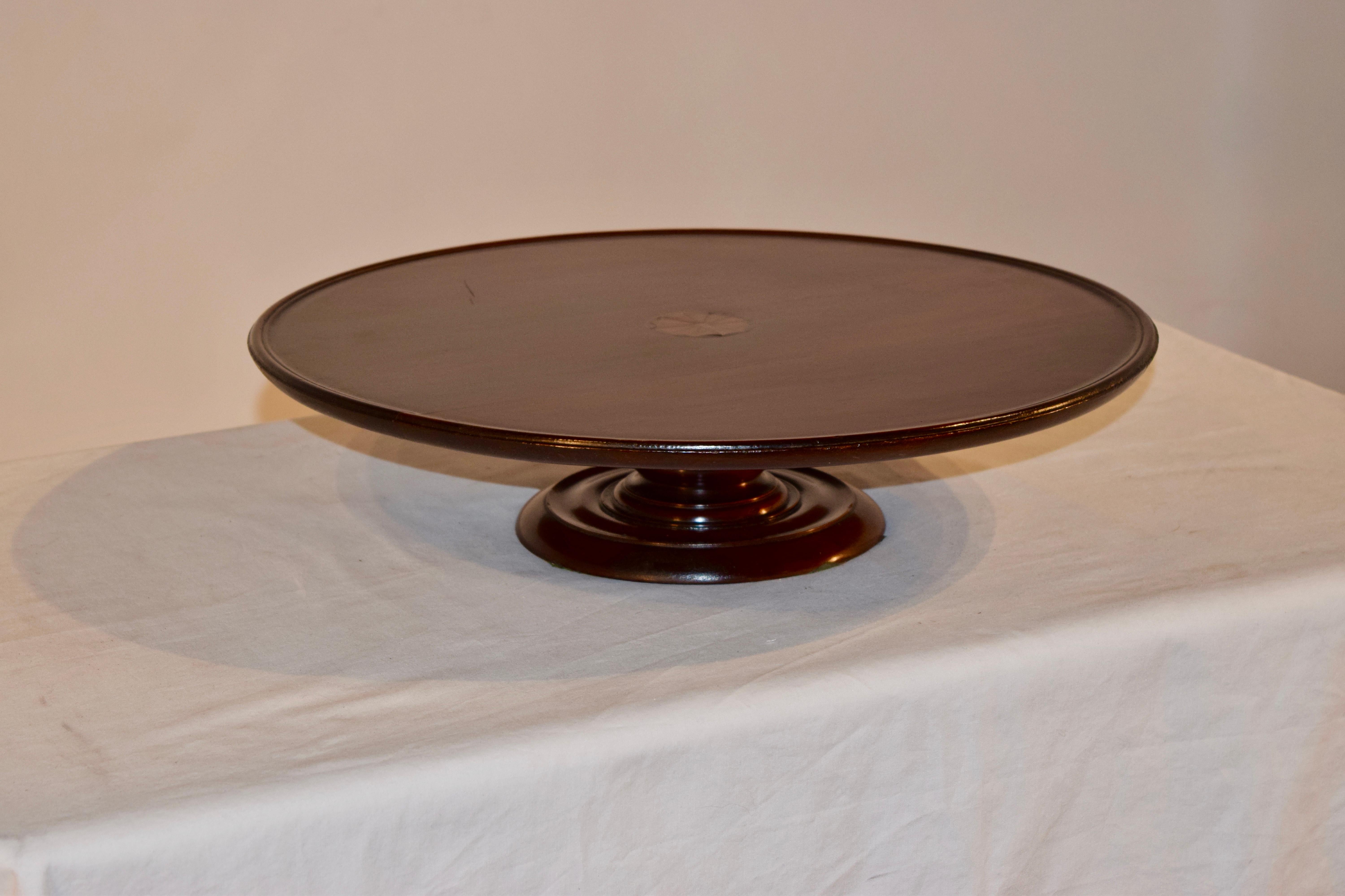 Mahogany lazy susan from England with a pie crust edge and a central inlay medallion of a fan. The base is nicely hand-turned.