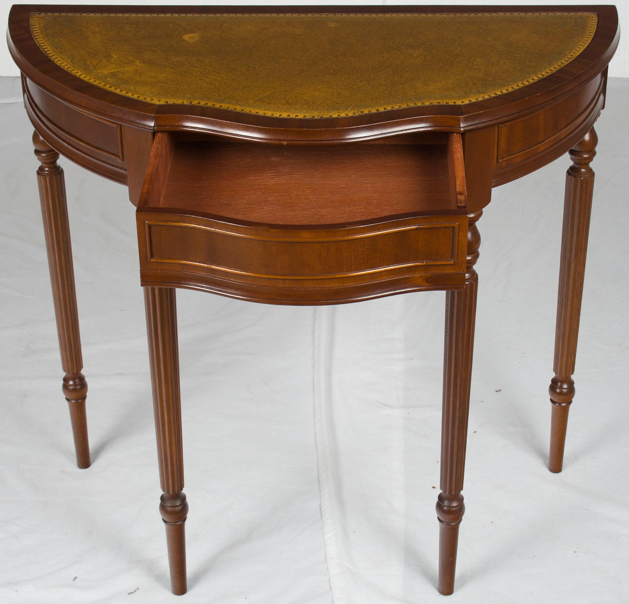 Beautifully done in mahogany with a leather top, this table boasts a classical elegance. This side table is a handy size (only 16.25? deep in the middle!) that will fit just about anywhere! This piece was made sometime around the year 1960.

The