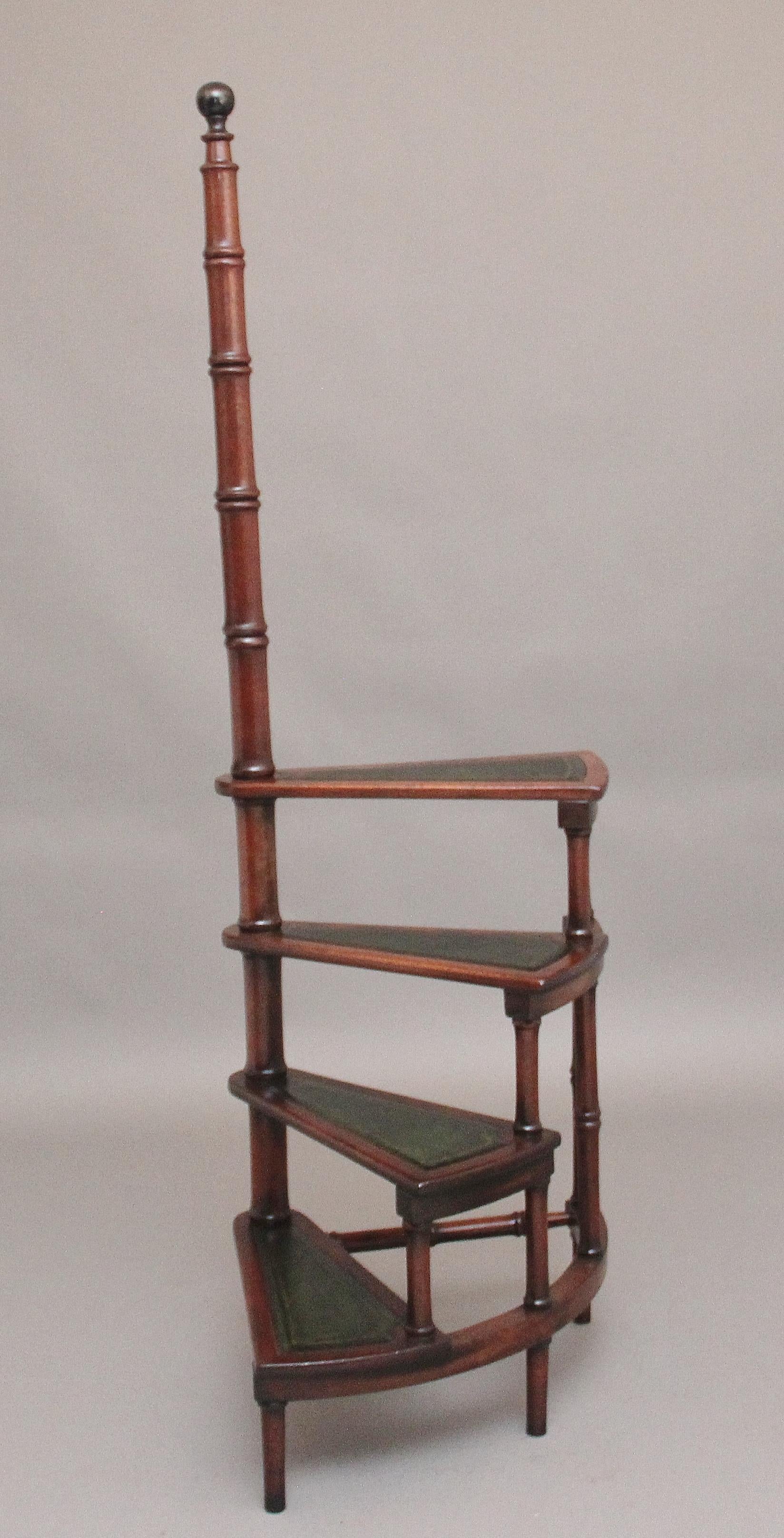 Juego de peldaños de biblioteca de caoba de mediados del siglo XX, compuesto por cuatro peldaños con cada peldaño forrado de un cuero verde decorado con grabados ciegos y dorados, apoyado en una columna torneada alta con un pomo torneado ebonizado