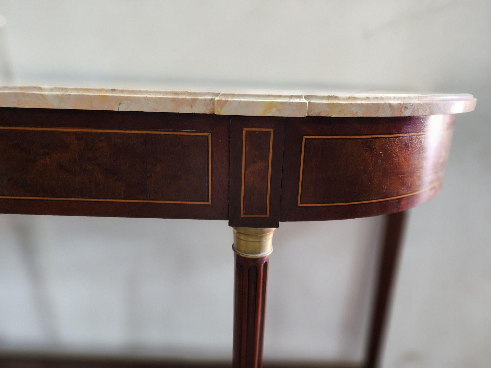 Console table in mahogany, Louis XVI design, with bronze elements and inlay, around 1950.